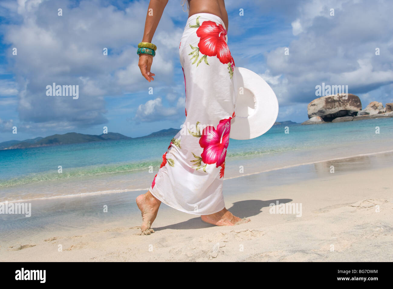 Femme sarong sur plage avec white hat Banque D'Images