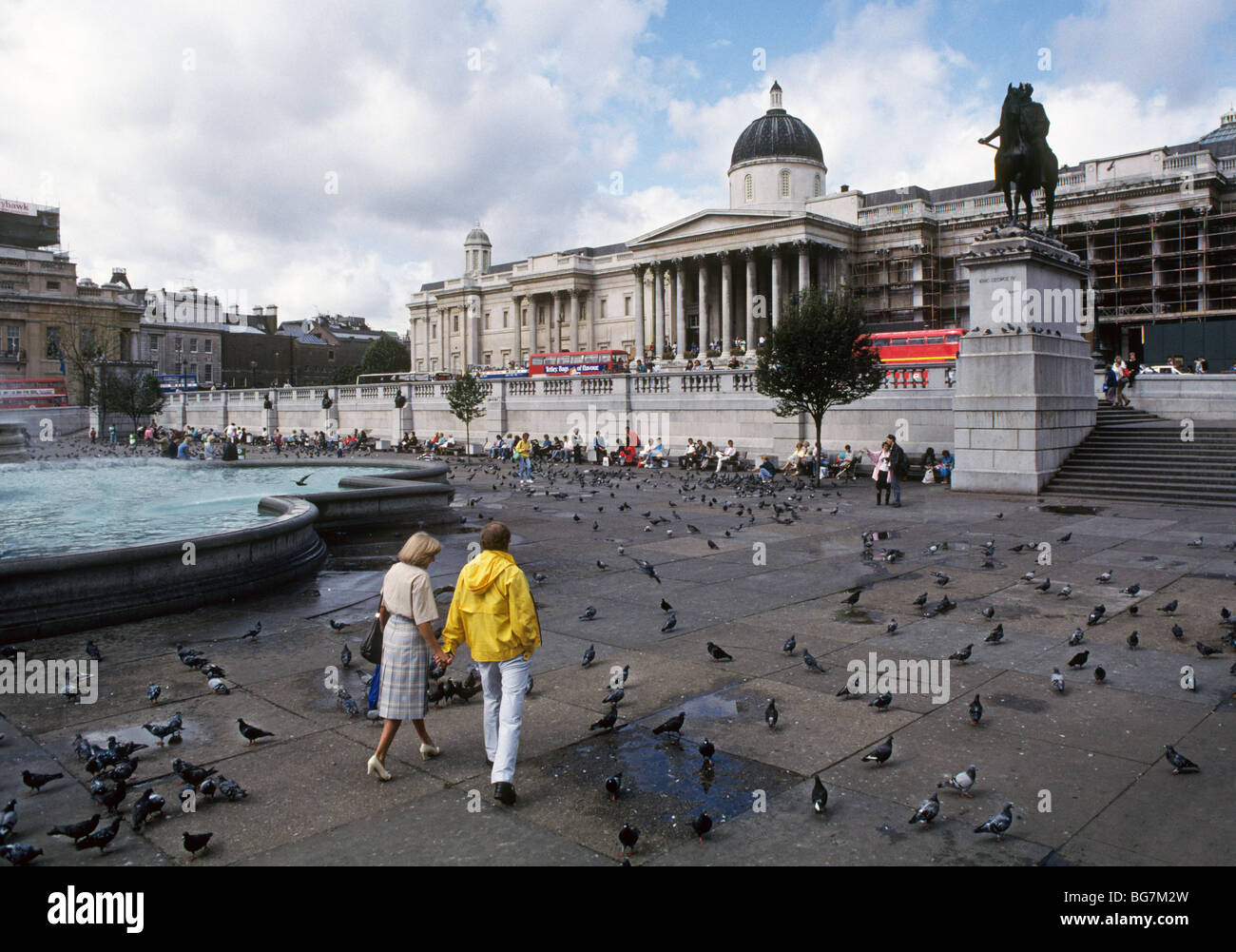 Les visiteurs se promenant dans Trafalgar Square après une tempête de pluie d'été, à Londres, en Angleterre Banque D'Images