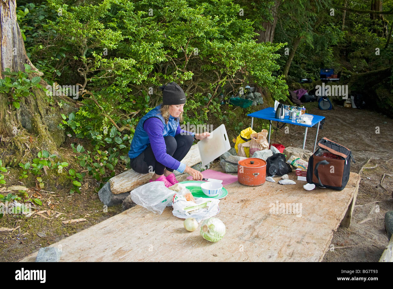 Kayak guide prépare le dîner au camping sur l'île de Willis dans l'archipel Broken Group, l'ouest du Canada Banque D'Images
