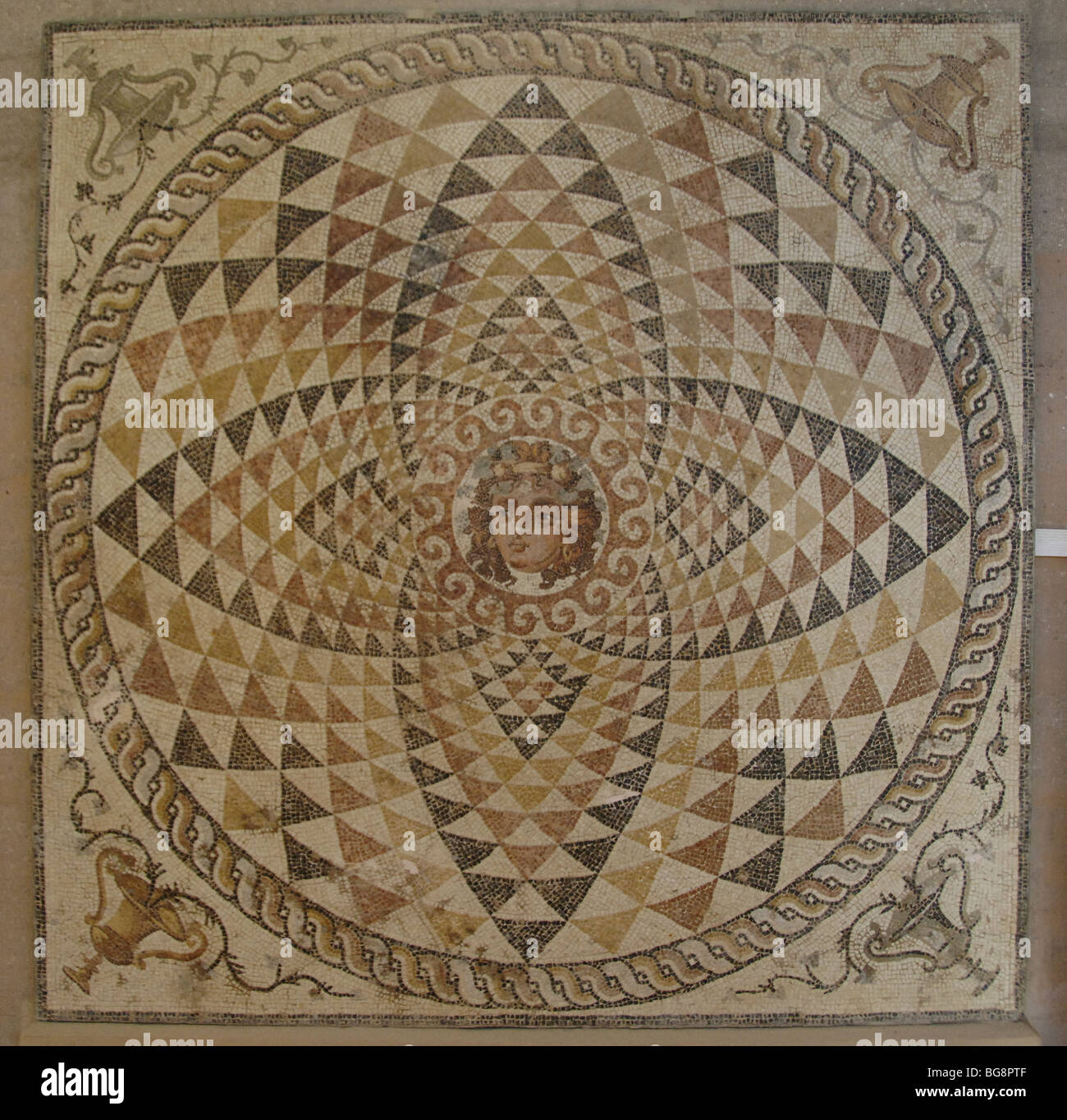 Mosaïque d'une villa romaine décorées de motifs géométriques et Dionysius tête avec fruit et ivy dans ses cheveux au centre. La Grèce. Banque D'Images