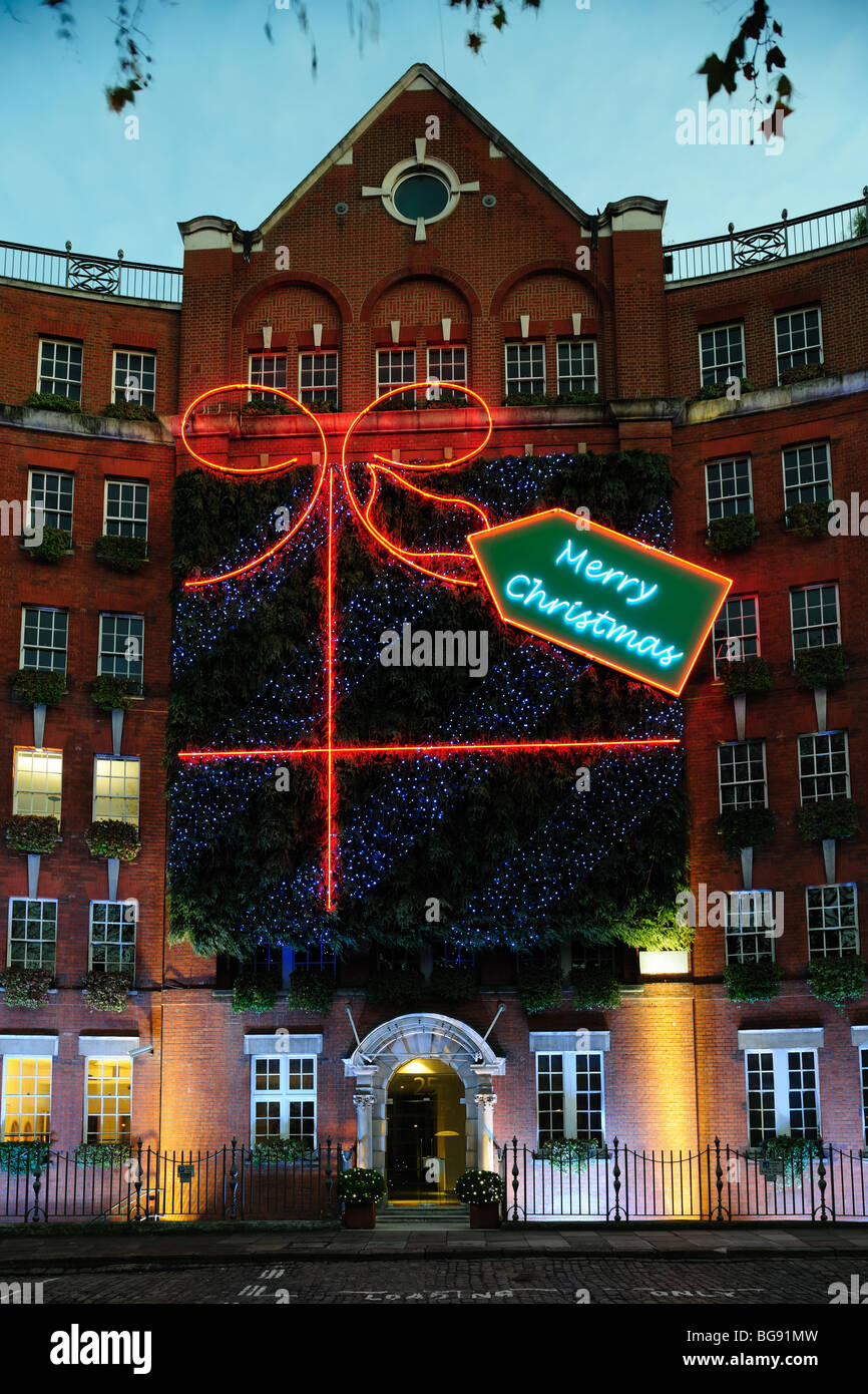 Façade d'un bâtiment en brique décorée avec un cadeau et joyeux Noël tag Banque D'Images