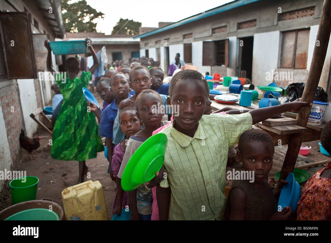 Les enfants se tenir dans une ligne de distribution alimentaire dans un orphelinat à Amuria, est de l'Ouganda. Banque D'Images