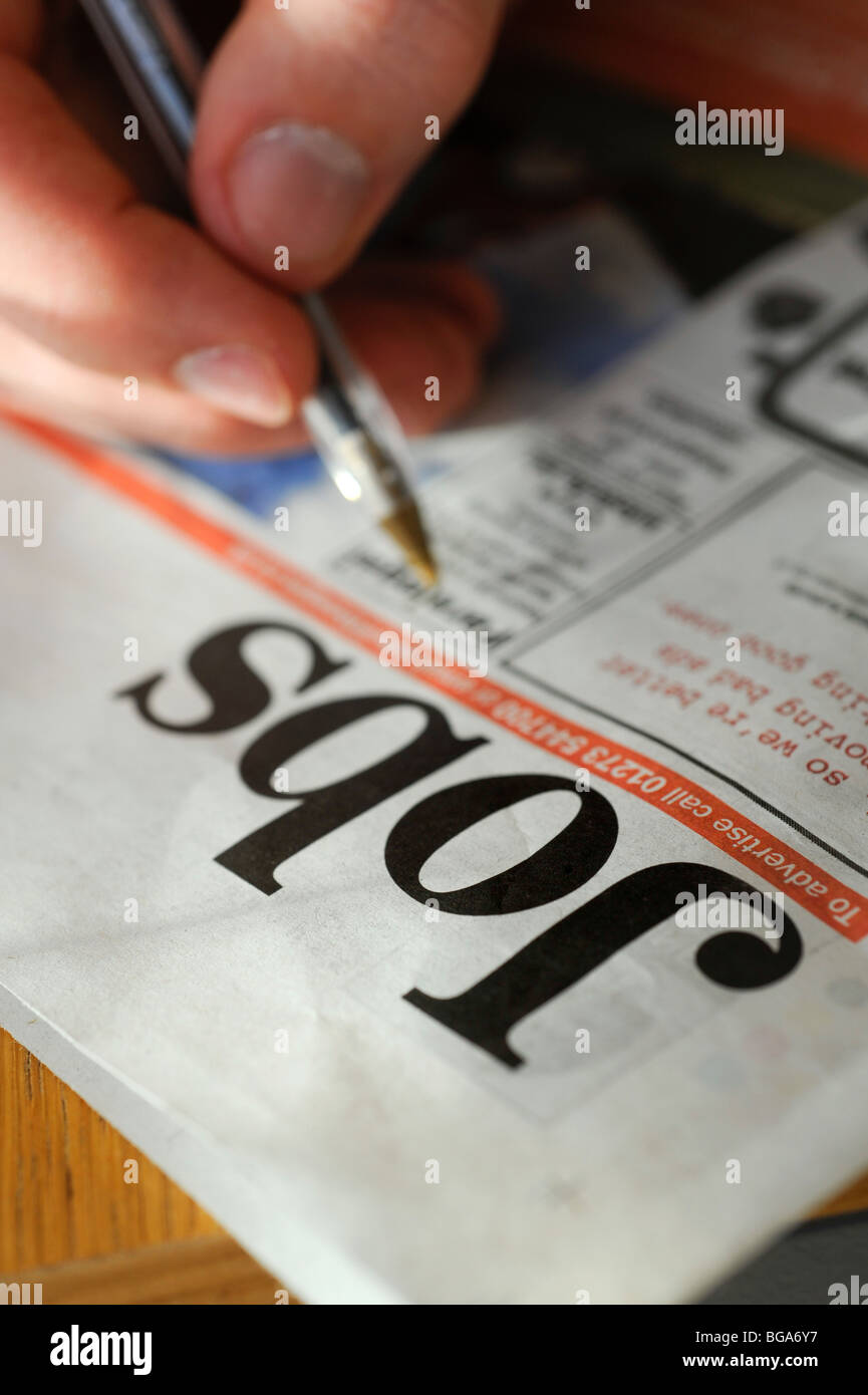 Une jeune personne à panneaux le journal local à la recherche d'un emploi dans la section classifiée. Photo par Jim Holden. Banque D'Images