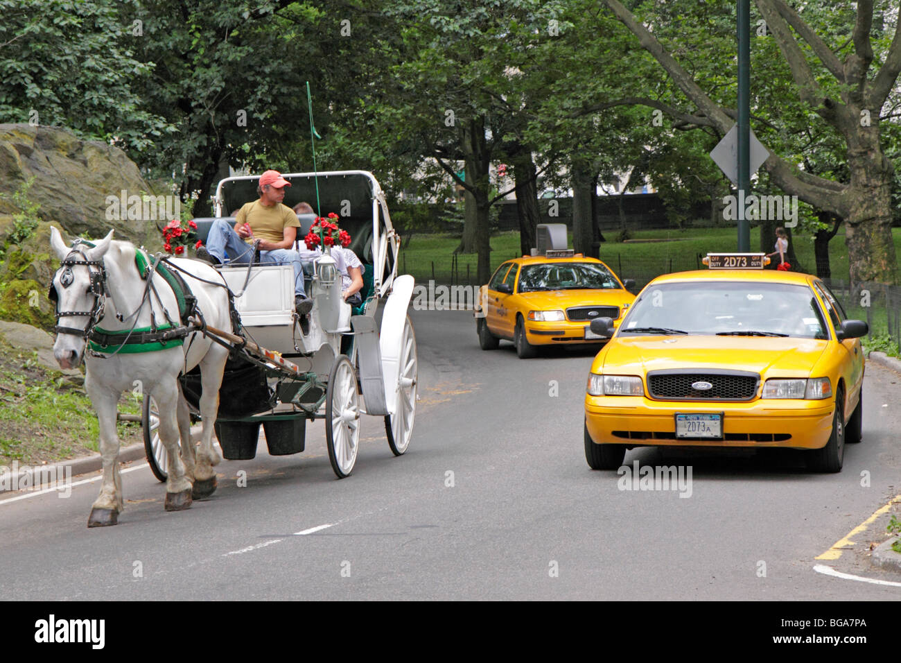 Voitures à cheval et les taxis jaunes à Central Park, à Manhattan, New York, United States Banque D'Images