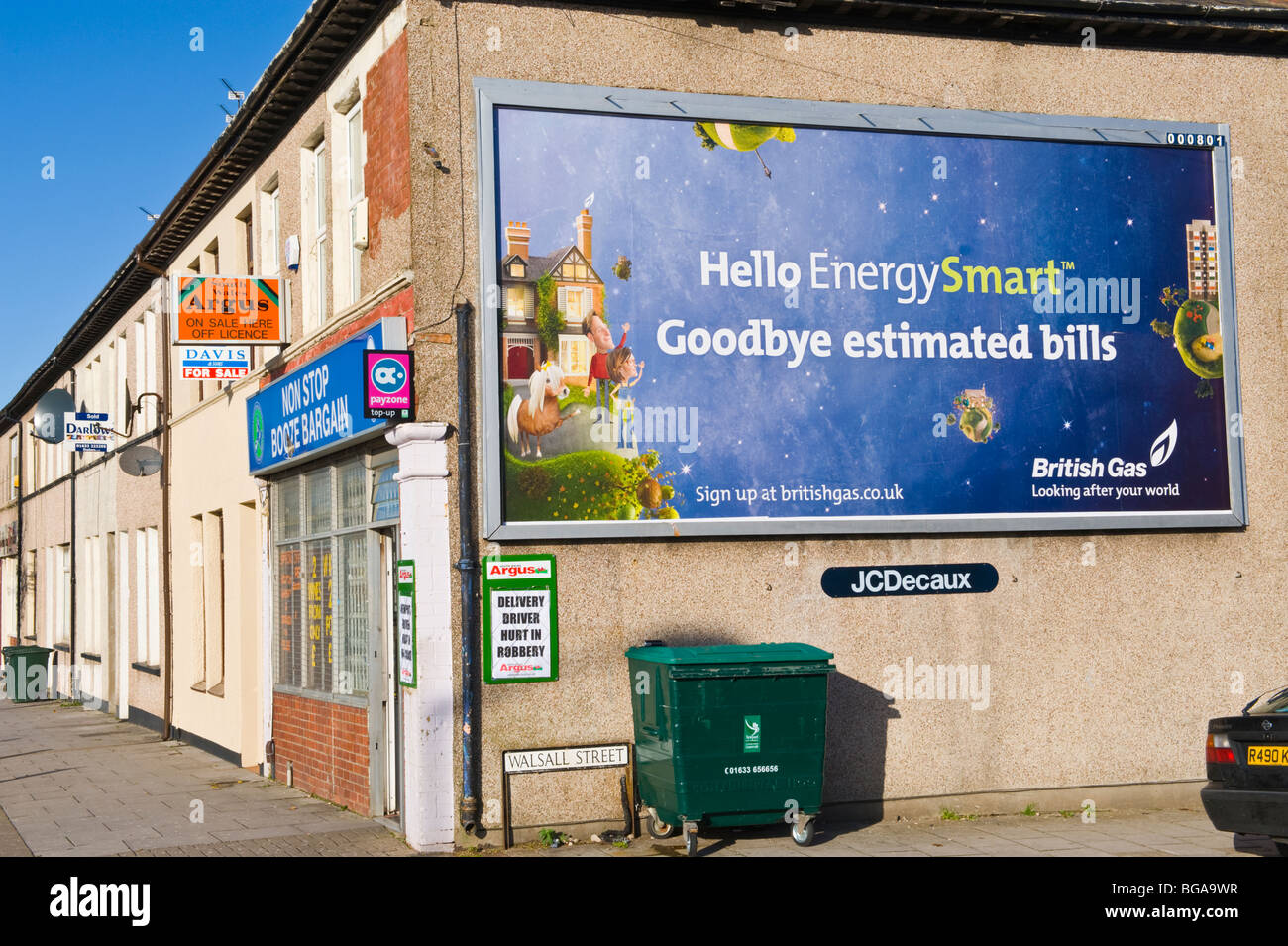JC Decaux site billboard affiche de British Gas sur fin mur de corner shop à Newport South Wales UK Banque D'Images