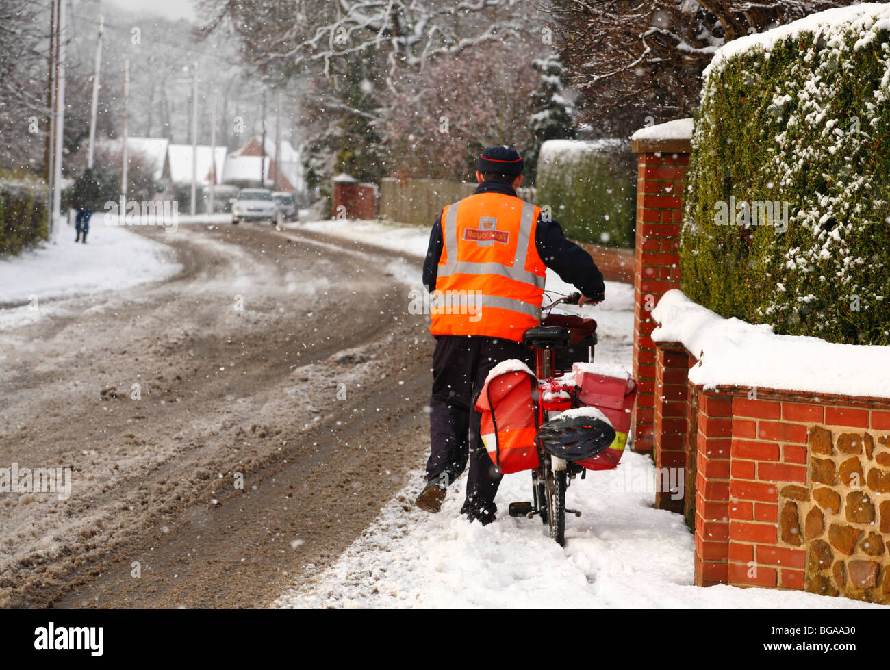 Luttes un facteur dans la neige avec son vélo pour livrer le message de Noël. Banque D'Images