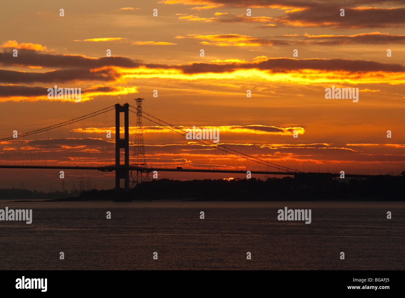 Le soleil se couche derrière la vieille Severn Bridge comme le trafic passe par Banque D'Images