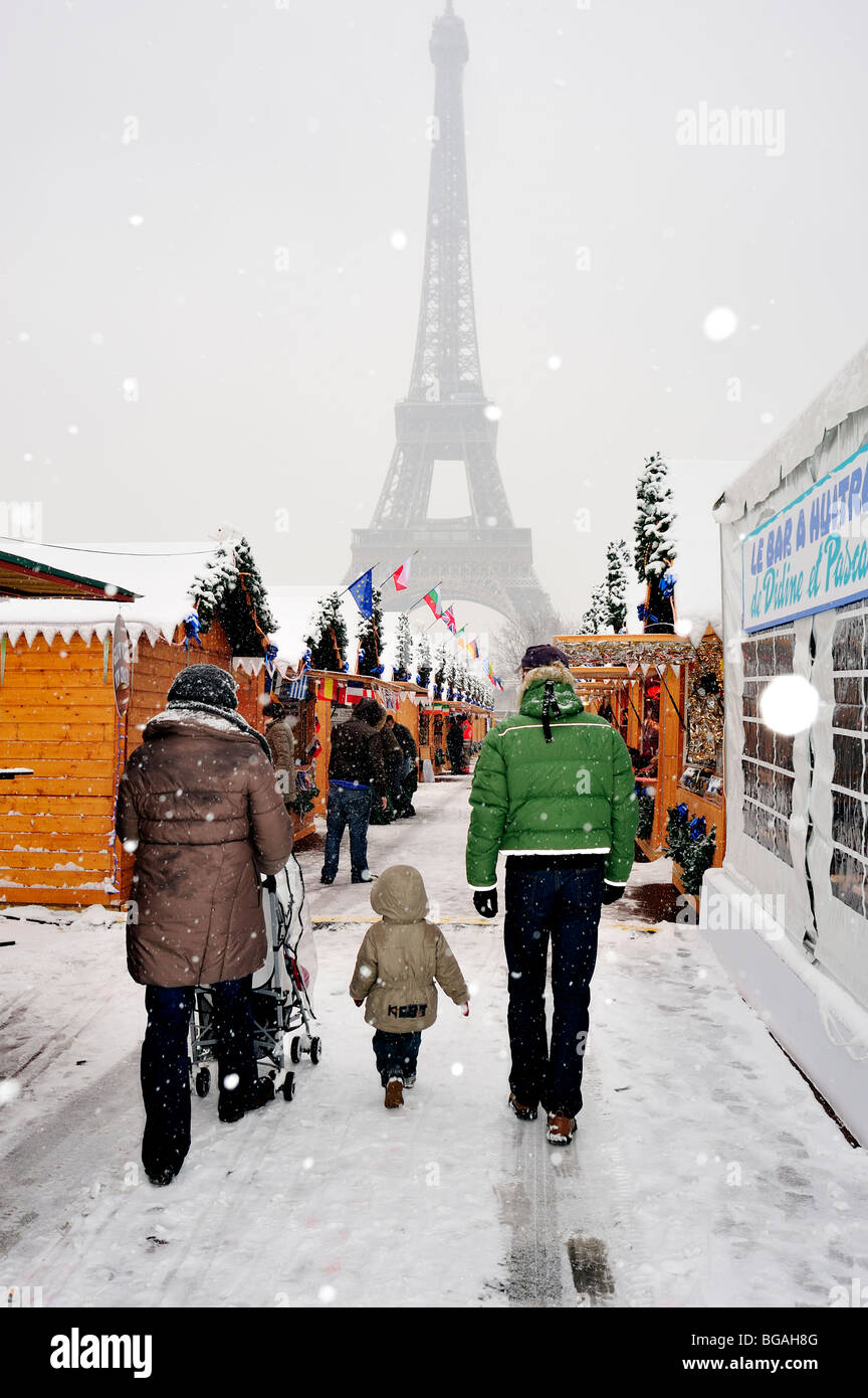 Paris, France, foule, famille avec enfants, marcher loin, arrière, tempête de neige hivernale, marché de Noël de Paris, marché de Noel, près de la Tour Eiffel Banque D'Images