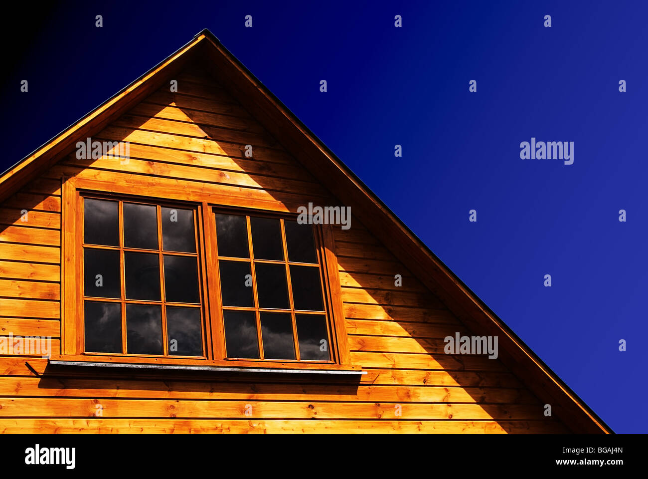 Le toit d'une maison en bois en milieu rural sur un fond de ciel bleu. Banque D'Images