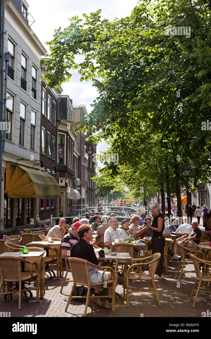 Des gens assis dans un bar à l'extérieur de l'ancien centre ville de Delft, Pays-Bas Banque D'Images
