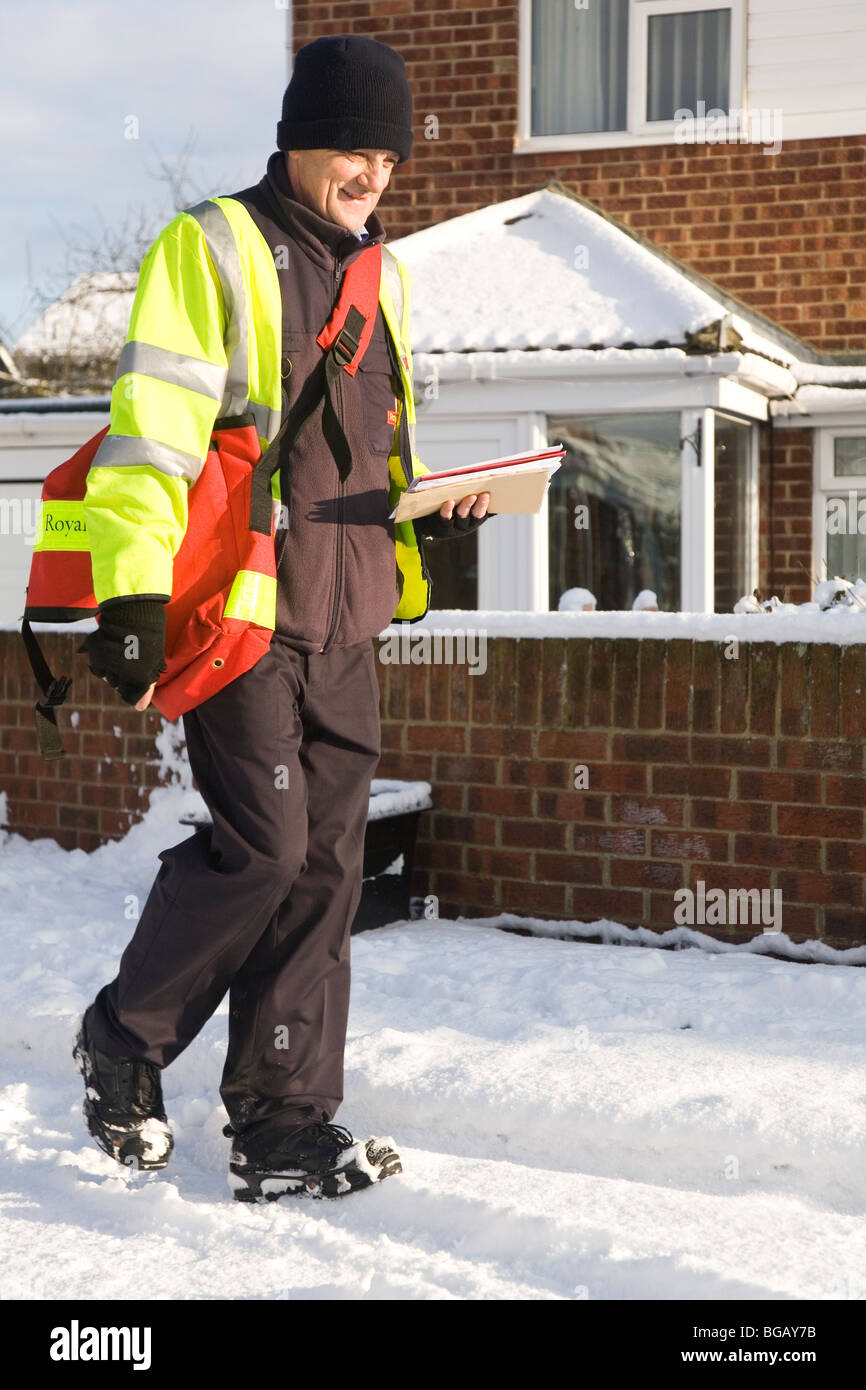 Un facteur fait ses livraisons de Noël malgré la neige qui a affecté l'état des routes dans le nord de l'Angleterre. Banque D'Images