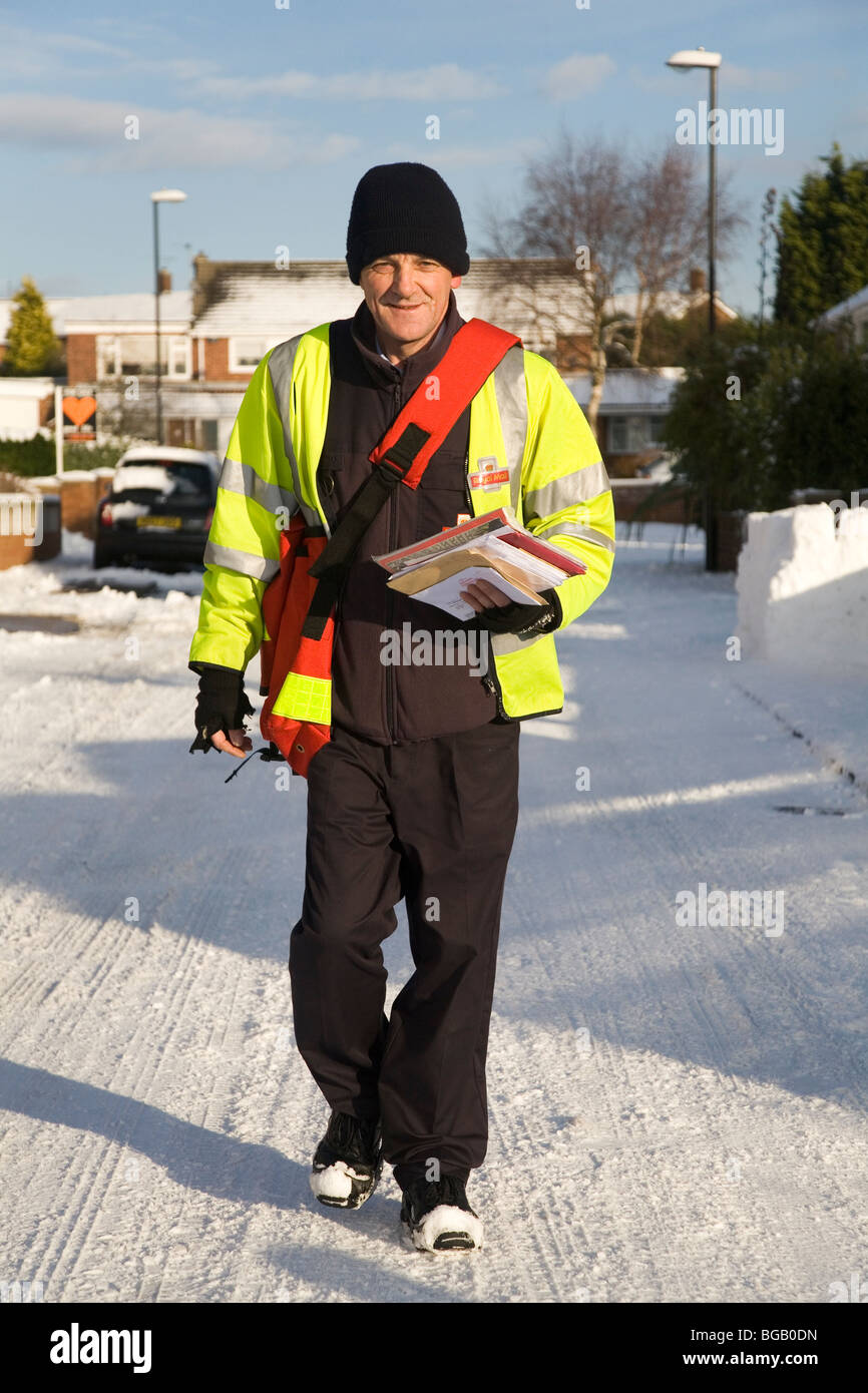 Un facteur fait ses livraisons de Noël malgré la neige qui a affecté l'état des routes dans le nord de l'Angleterre. Banque D'Images