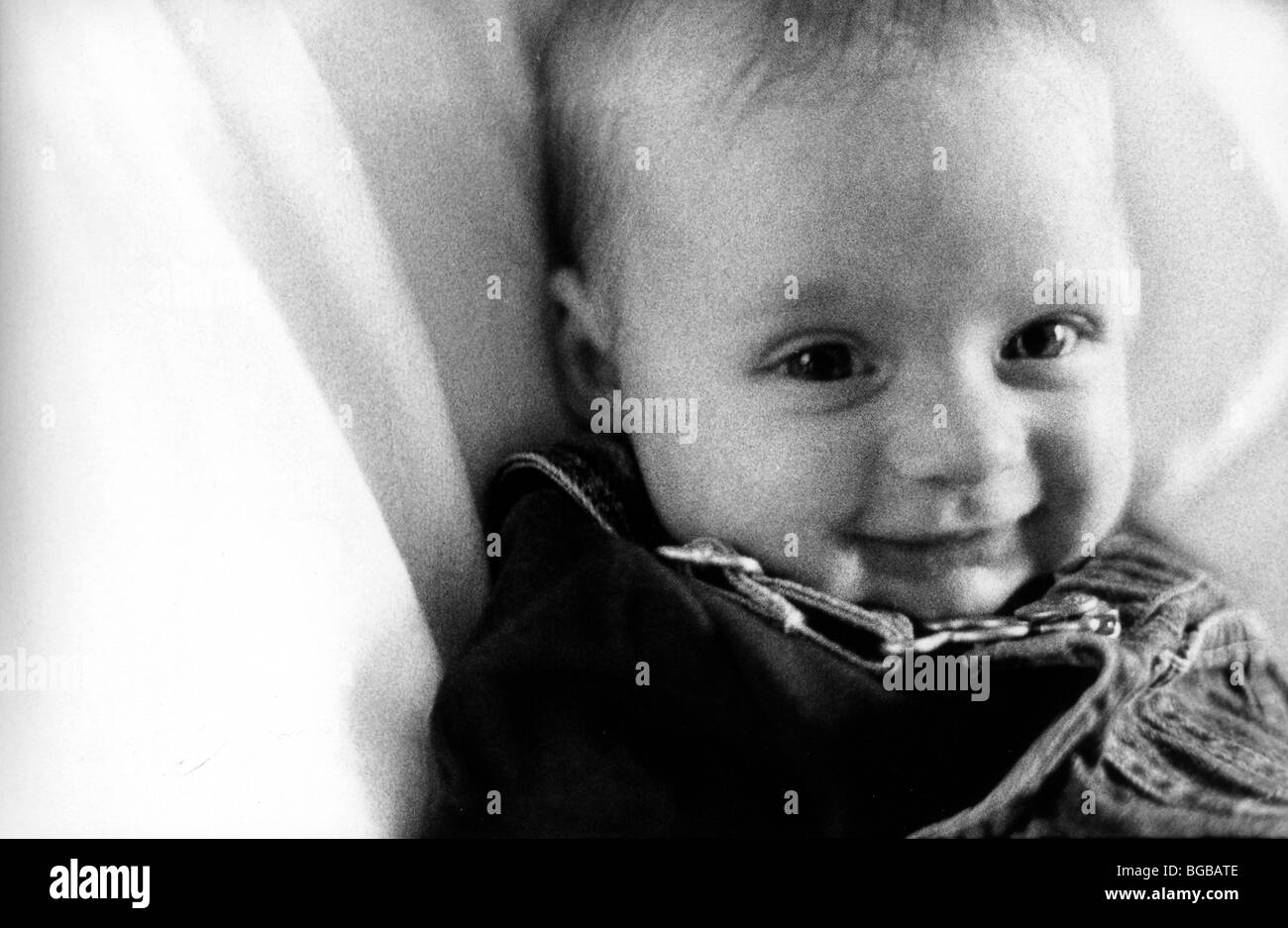 Photographie de bébé fille fille noir blanc lit sourire granuleuse UK Banque D'Images