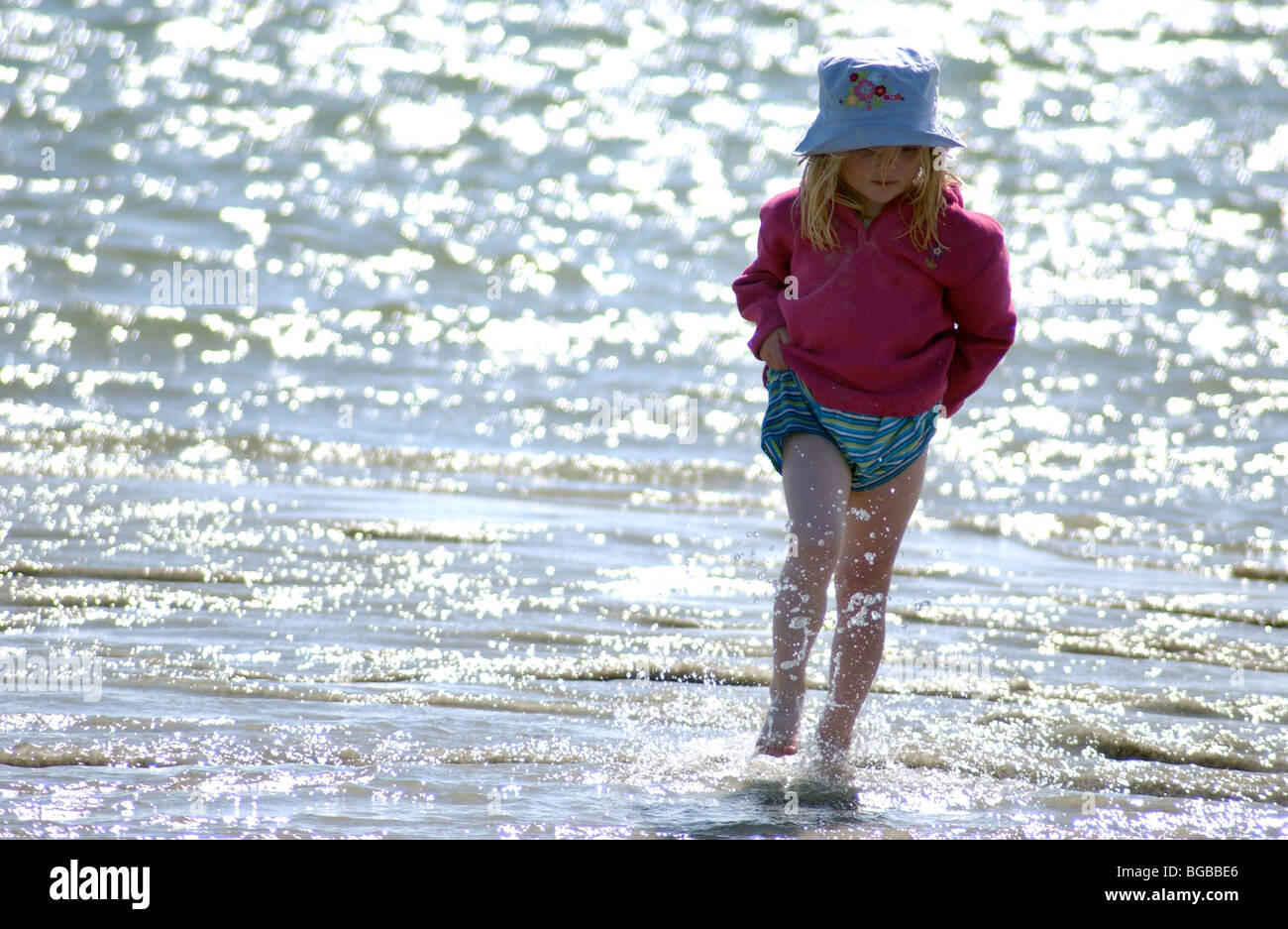 Image Photo d'enfant jouant sur la plage côtière dans l'été à marée basse UK. Banque D'Images