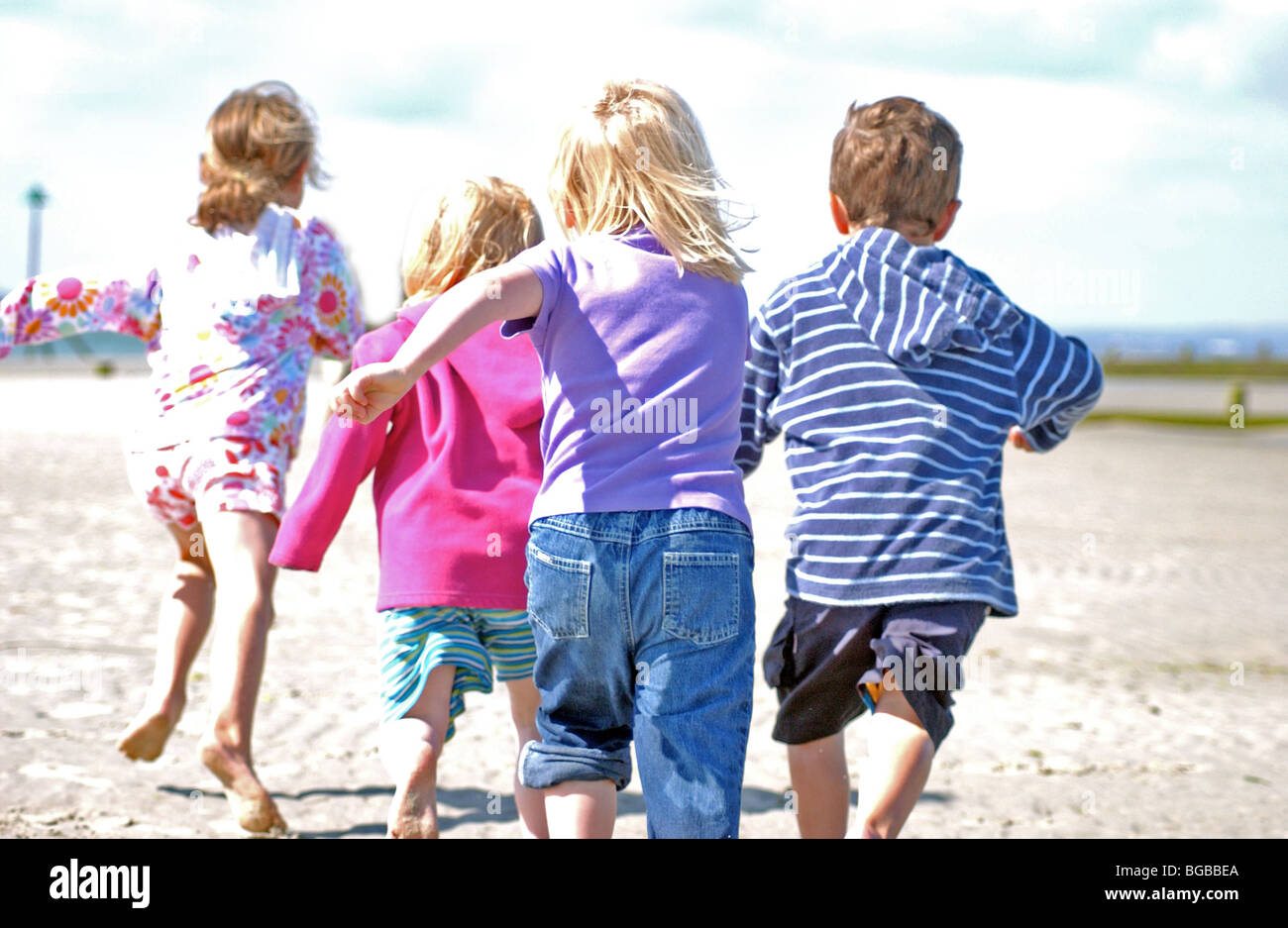 Image Photo d'enfants jouant sur la plage côtière dans l'été à marée basse UK. Banque D'Images