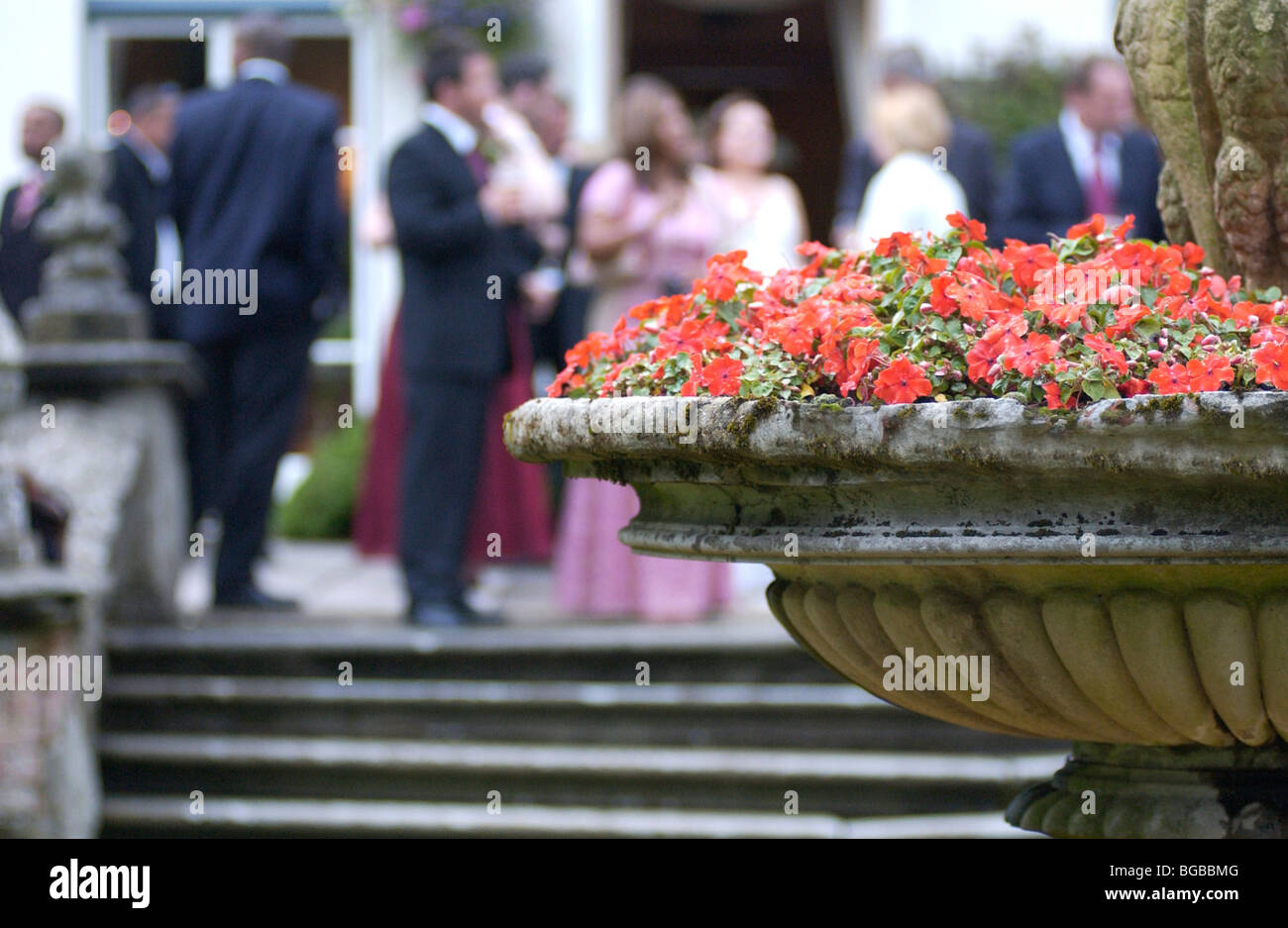 Image libre photo de pot de fleur traditionnelle dans un jardin avec une réception de mariage dans l'arrière-plan Banque D'Images