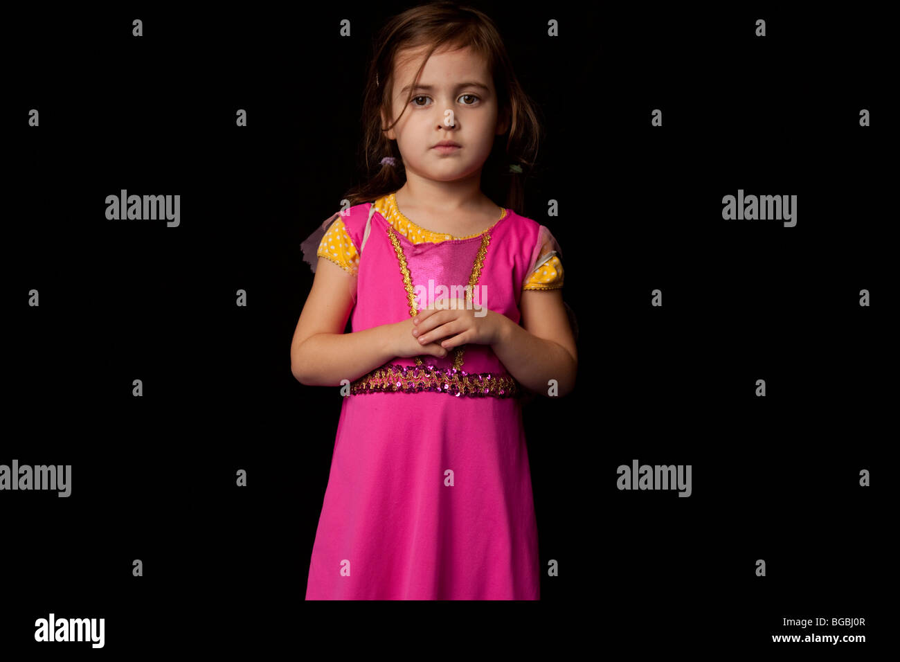 Young girl looking at camera en robe rose Banque D'Images