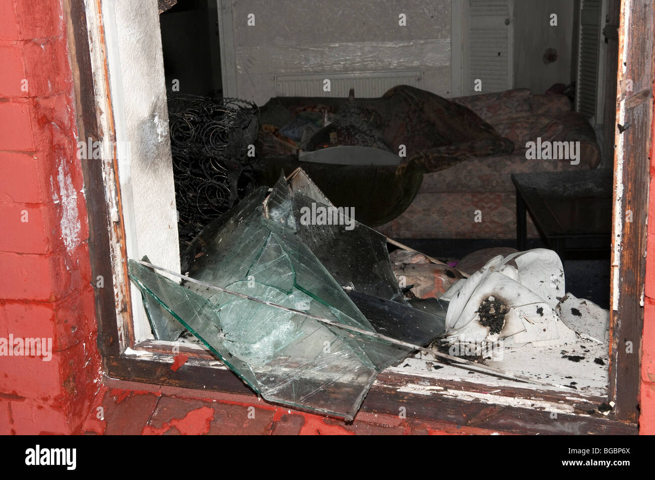 La fenêtre brisée montrant les dégâts causés par le feu au lit de l'essence à la bombe Banque D'Images