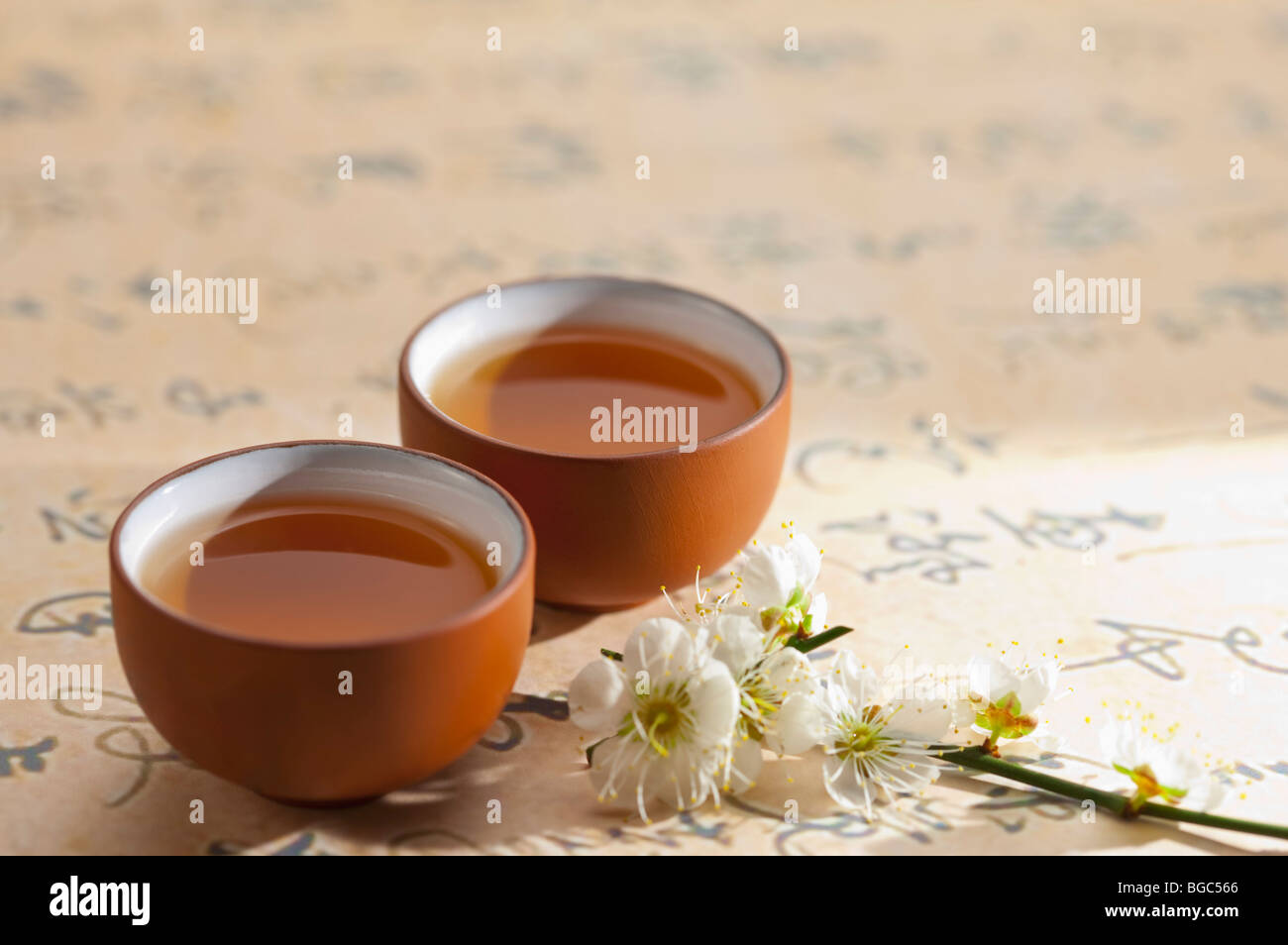 Close-up de deux tasses de thé et des fleurs sur la calligraphie Banque D'Images