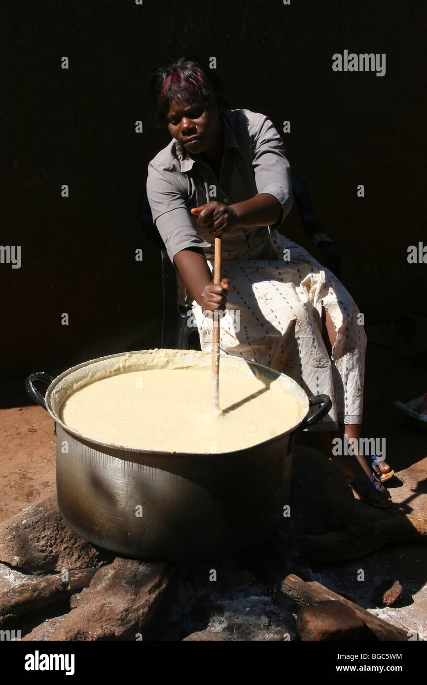 Une grande casserole de cuisson femme de bouillie, en Zambie, l'Afrique Banque D'Images