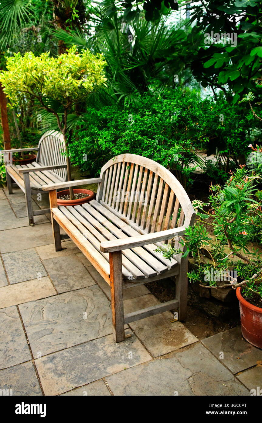 Jardin verdoyant avec aménagement paysager et des bancs en pierre Banque D'Images