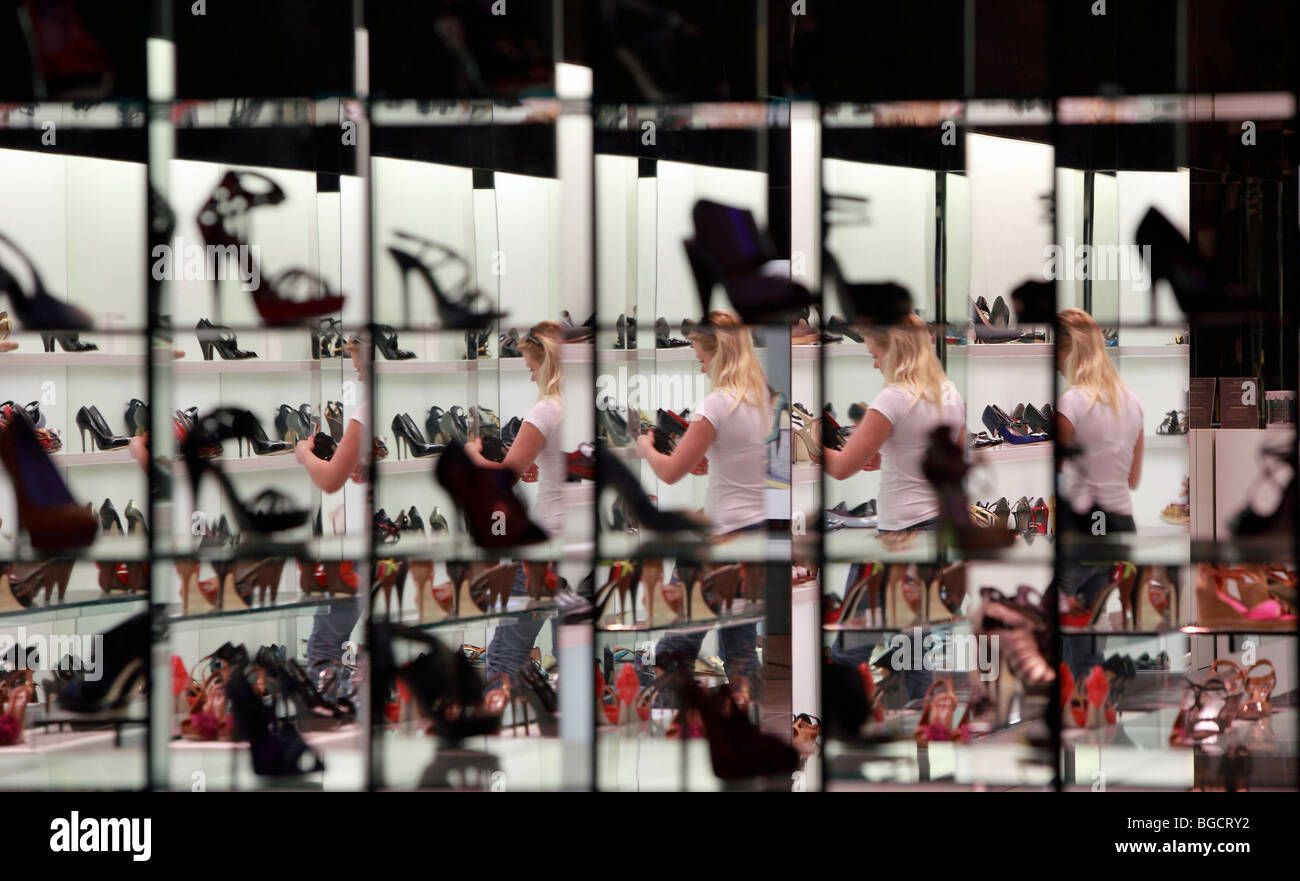 Une femme à la recherche de chaussures dans un magasin de chaussures, Dubaï, Émirats Arabes Unis Banque D'Images