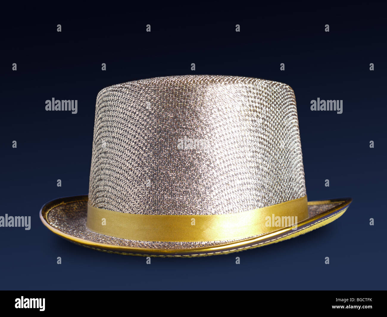 Golden top hat tourné sur surface bleu foncé Banque D'Images
