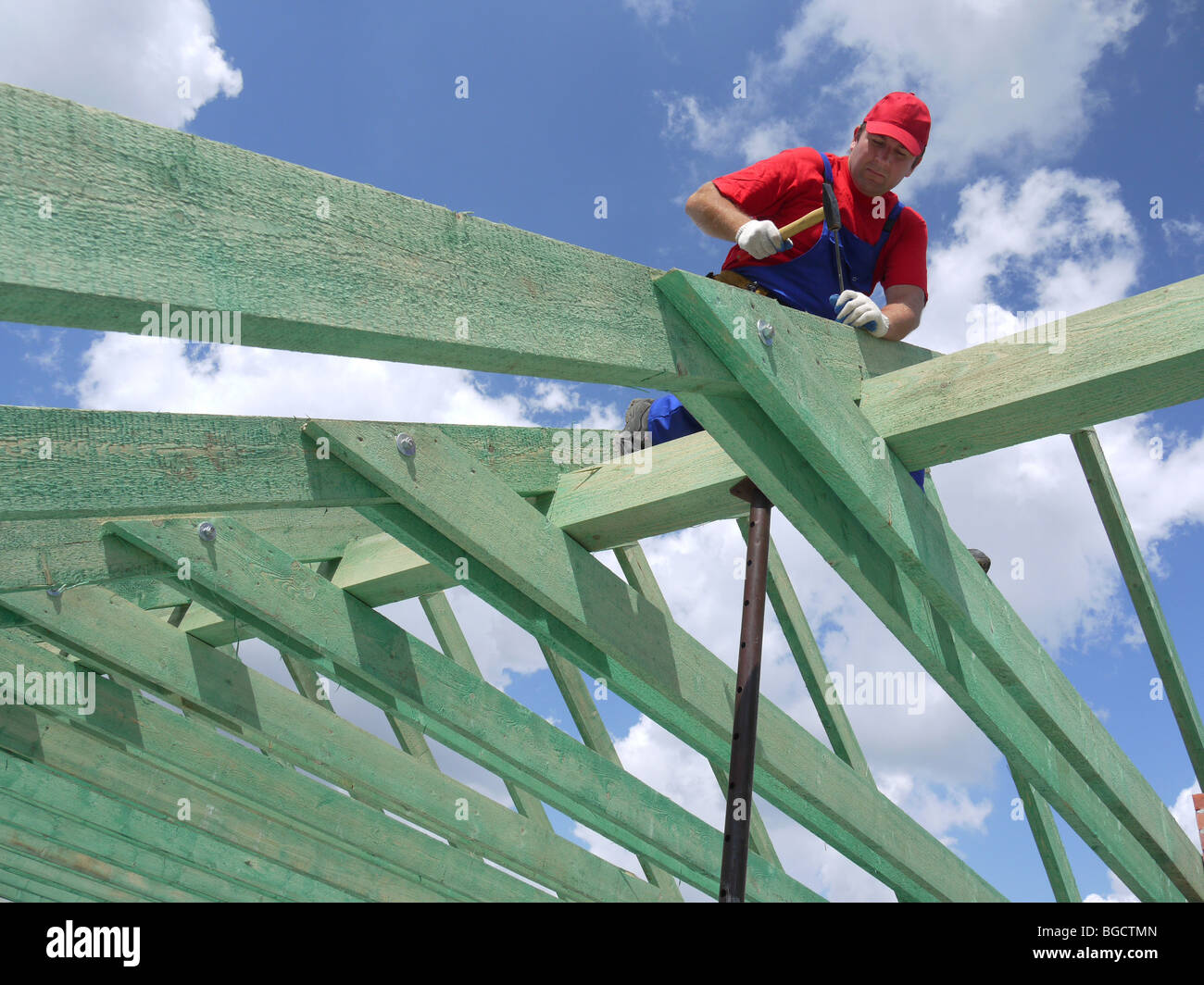 Carpenter la conduite d'un clou dans chambre rafter poutre ossature Banque D'Images