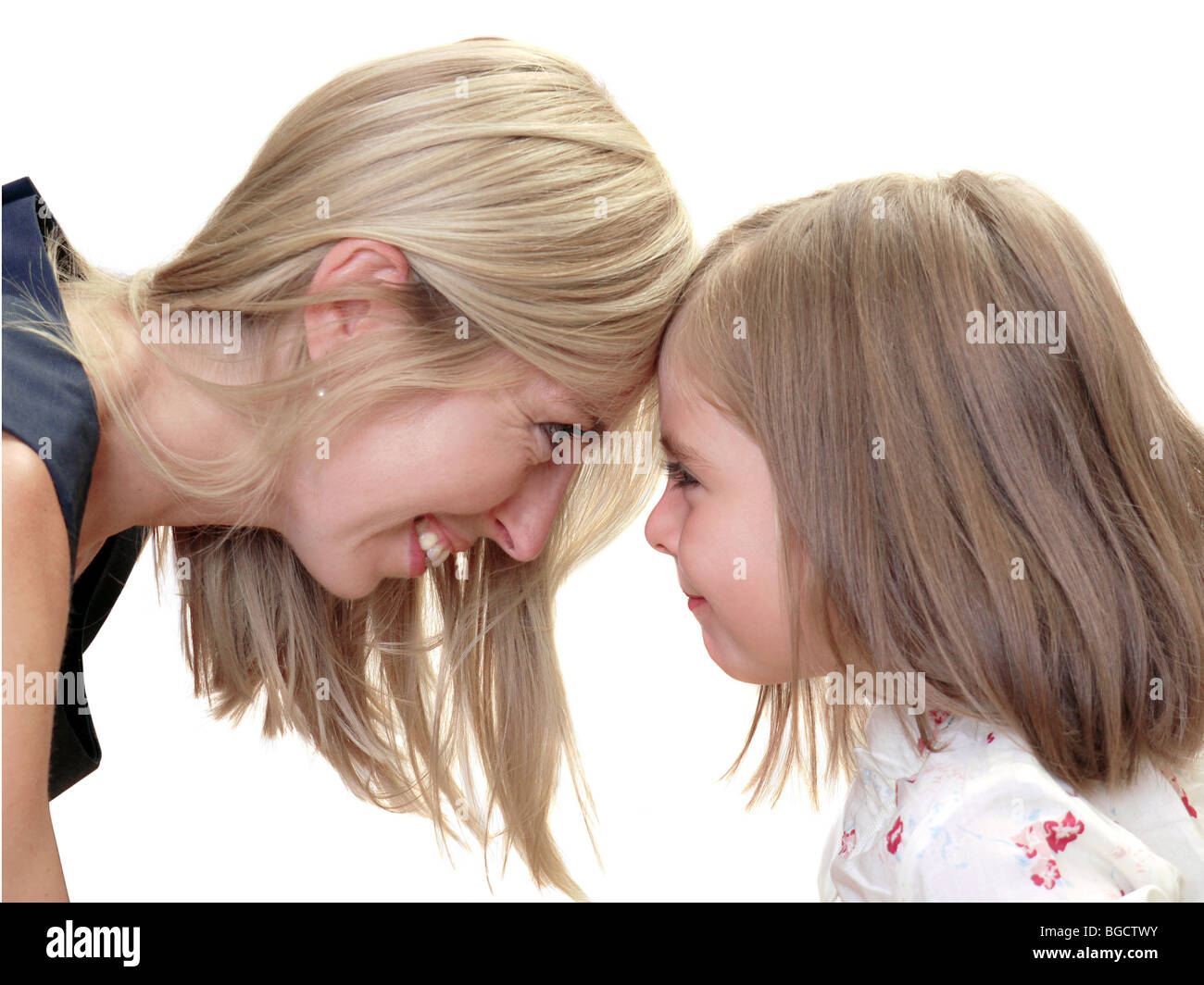 Jeune mère et sa fille peu cute touchent front over white background Banque D'Images