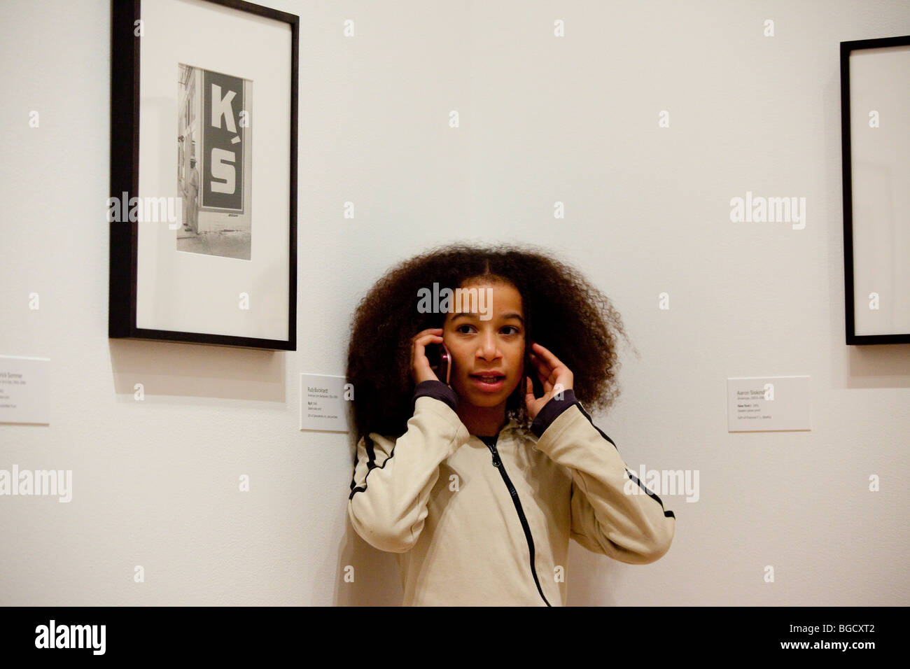 Fille sur un téléphone cellulaire à l'intérieur de MoMa à New York City Banque D'Images