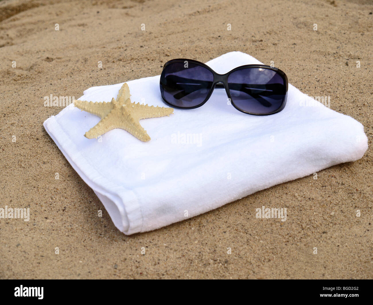 Lunettes de soleil et d'étoiles de femelle sur blanc serviette de bain sur une plage Banque D'Images