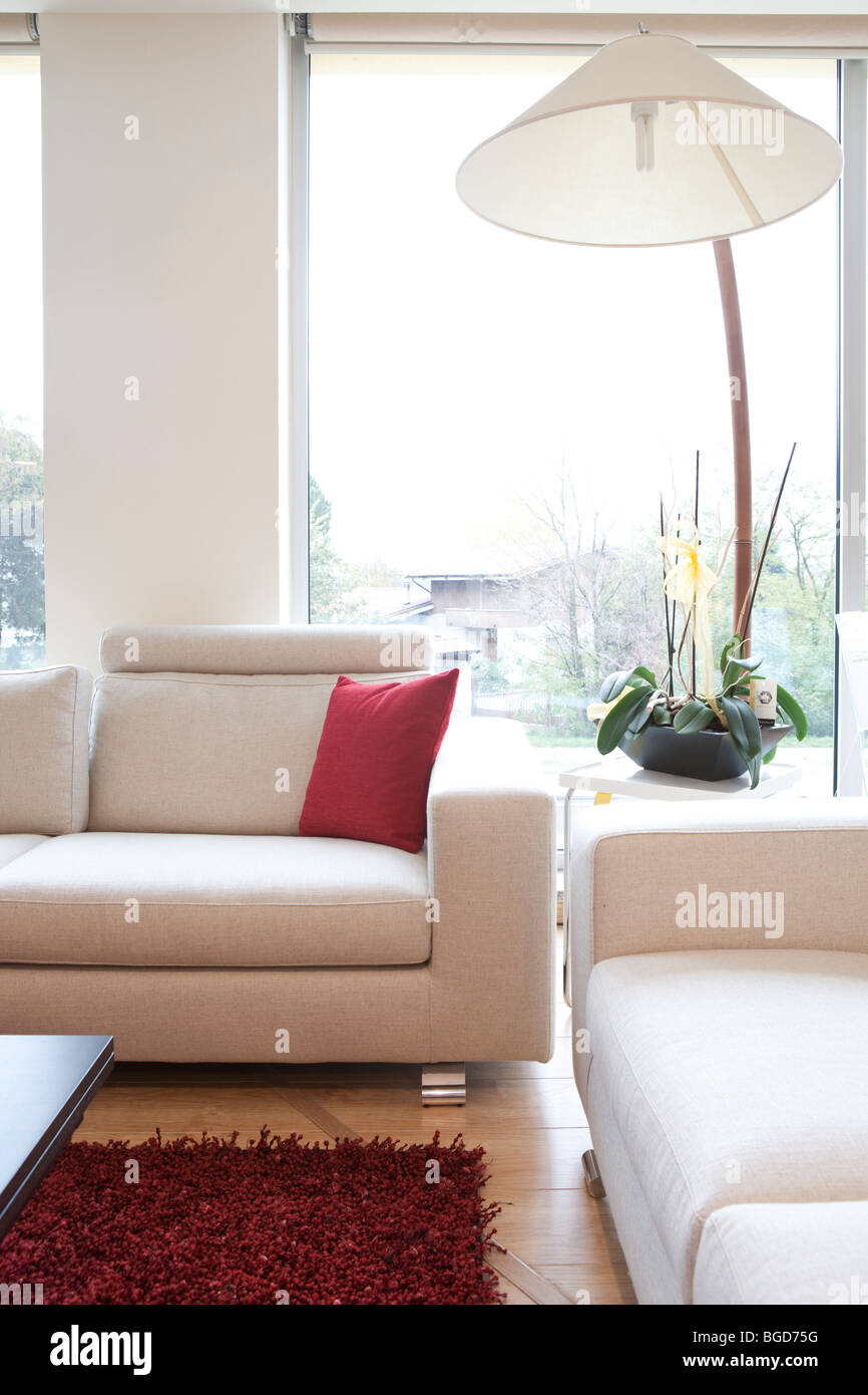 Canapés blanc avec tapis rouge et lampe moderne Banque D'Images