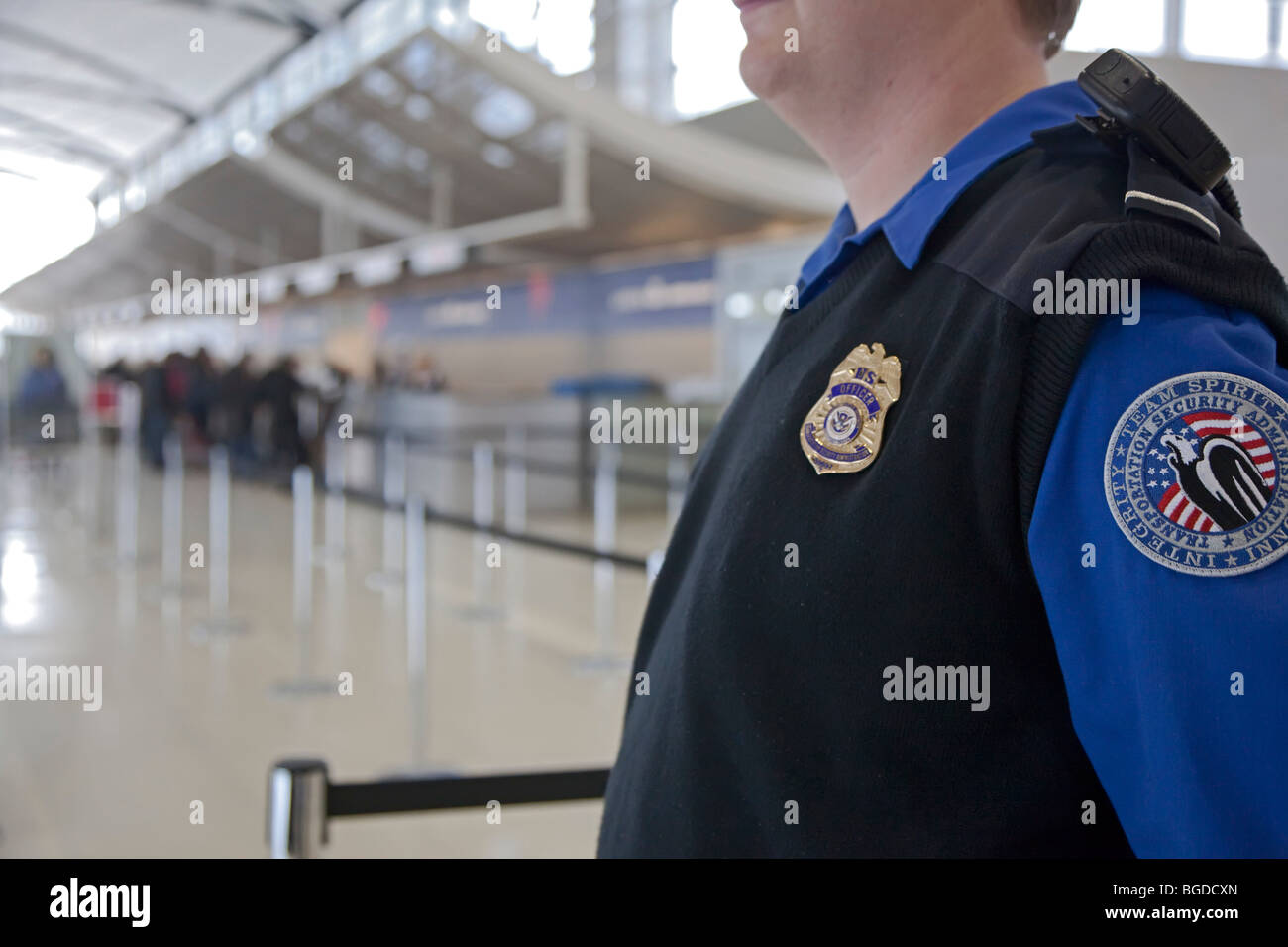 Romulus, Michigan - Un agent de sécurité surveille les passagers arrivant à l'Aéroport Métropolitain de Détroit. Banque D'Images