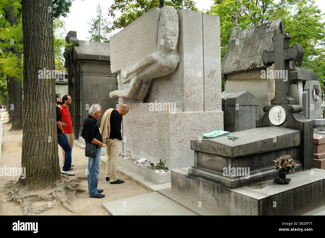 Quatre hommes visitant le tombeau d'Oscar Wilde, cimetière du Père Lachaise, Menilmontant, Paris, France Banque D'Images
