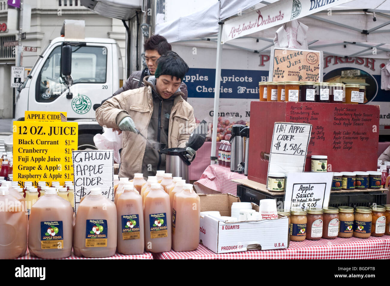 Chaudement habillé hommes louches le cidre chaud à la vente à l'hiver dans la région de Union Square greenmarket agriculteurs NYC Banque D'Images