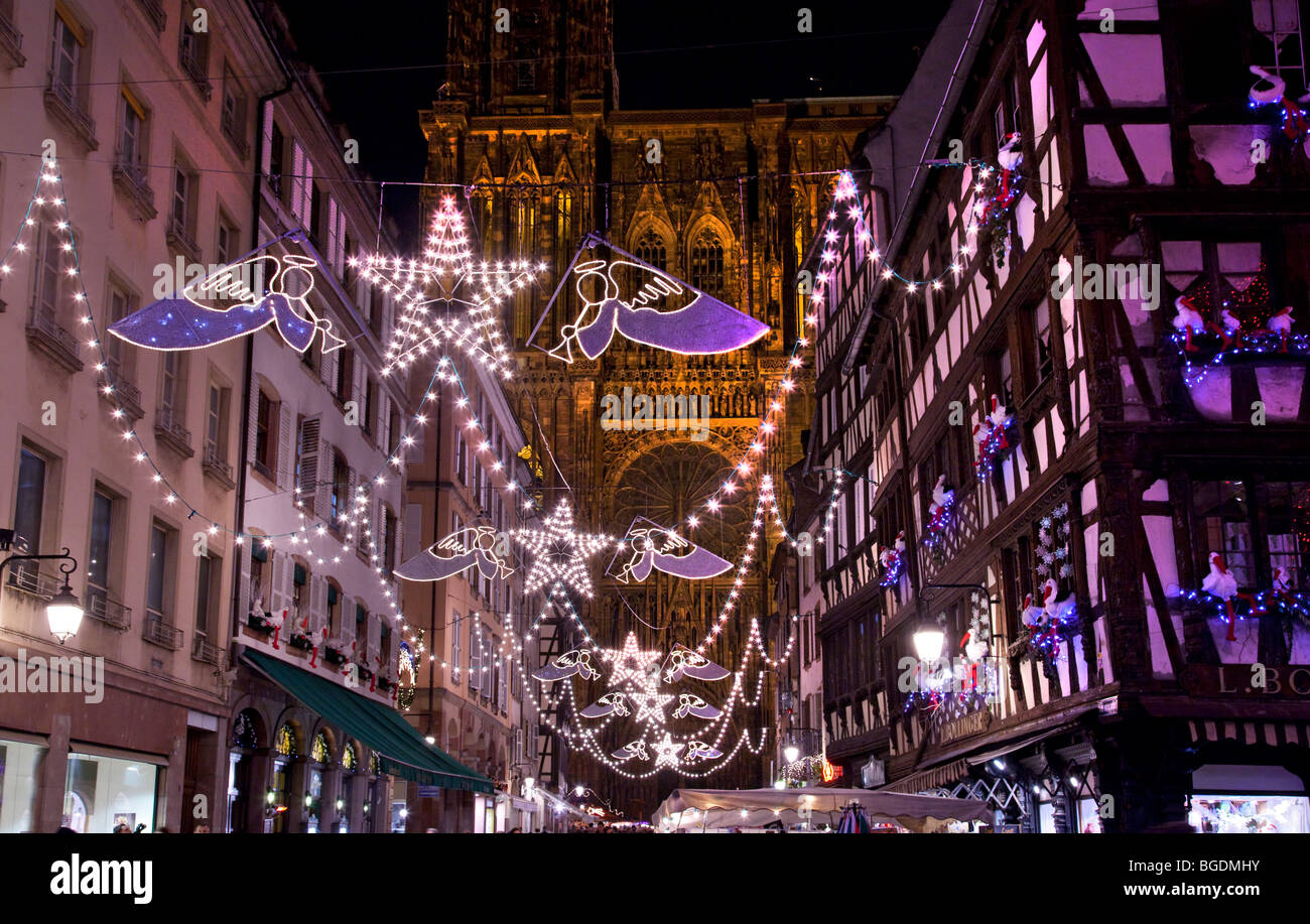 Les lumières de Noël dans les rues de Strasbourg, France avec la cathédrale en arrière-plan et de vieux bâtiments en bois. Banque D'Images