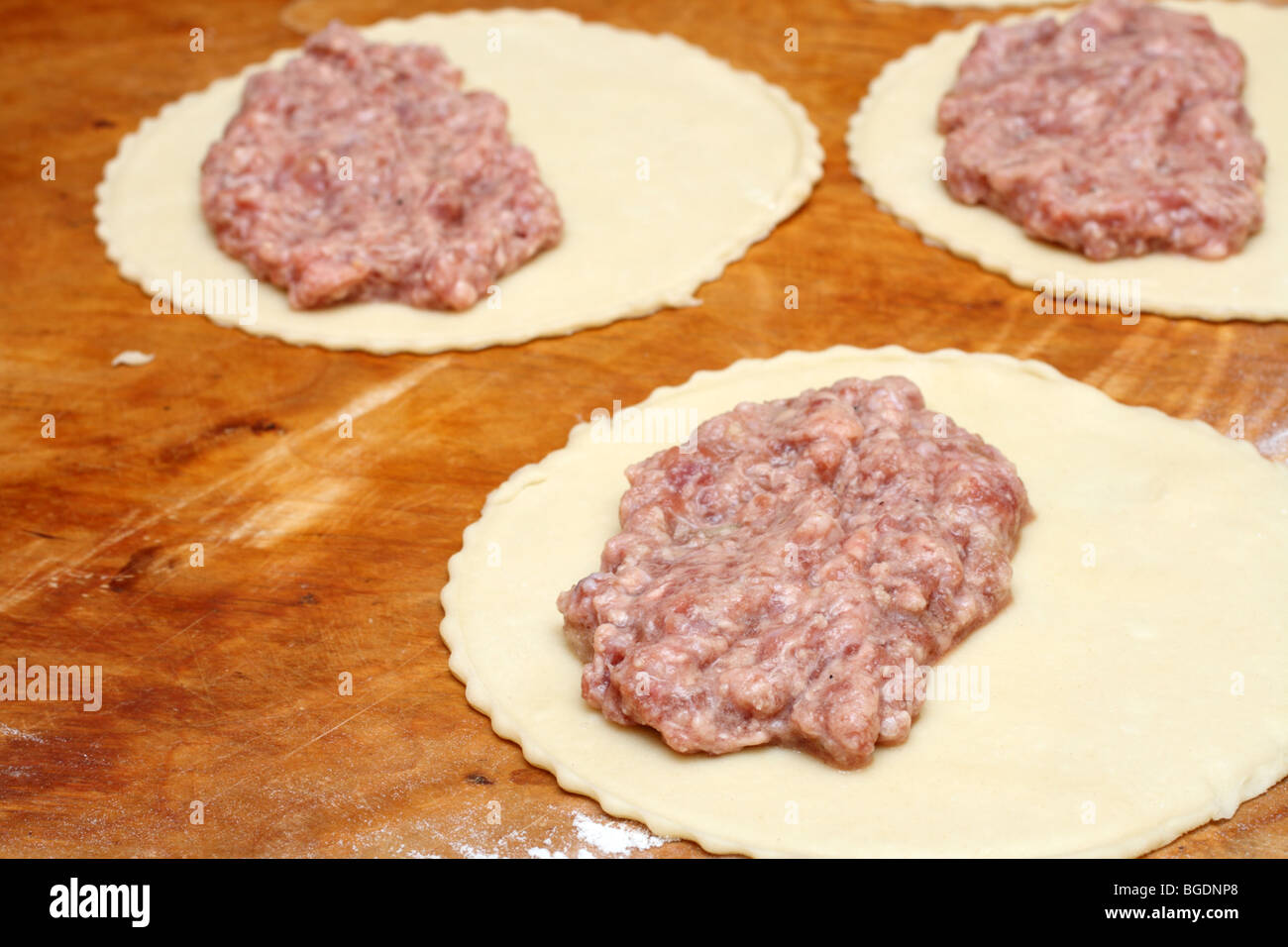 Les matières semi-finis patty avec de la viande sur planche de bois Banque D'Images