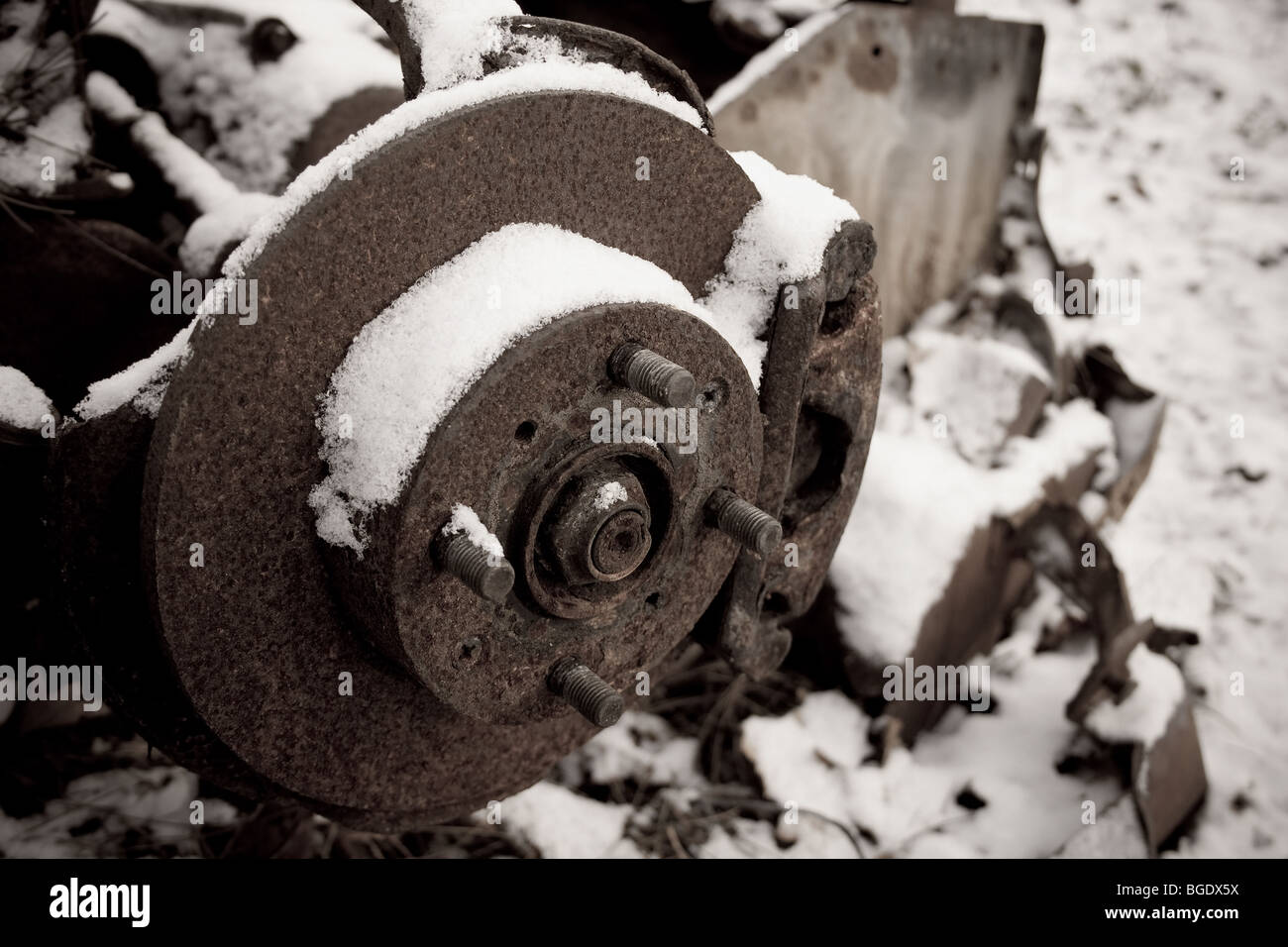 Une vieille voiture rouillée et l'essieu avant dans la neige, abandonné. Banque D'Images