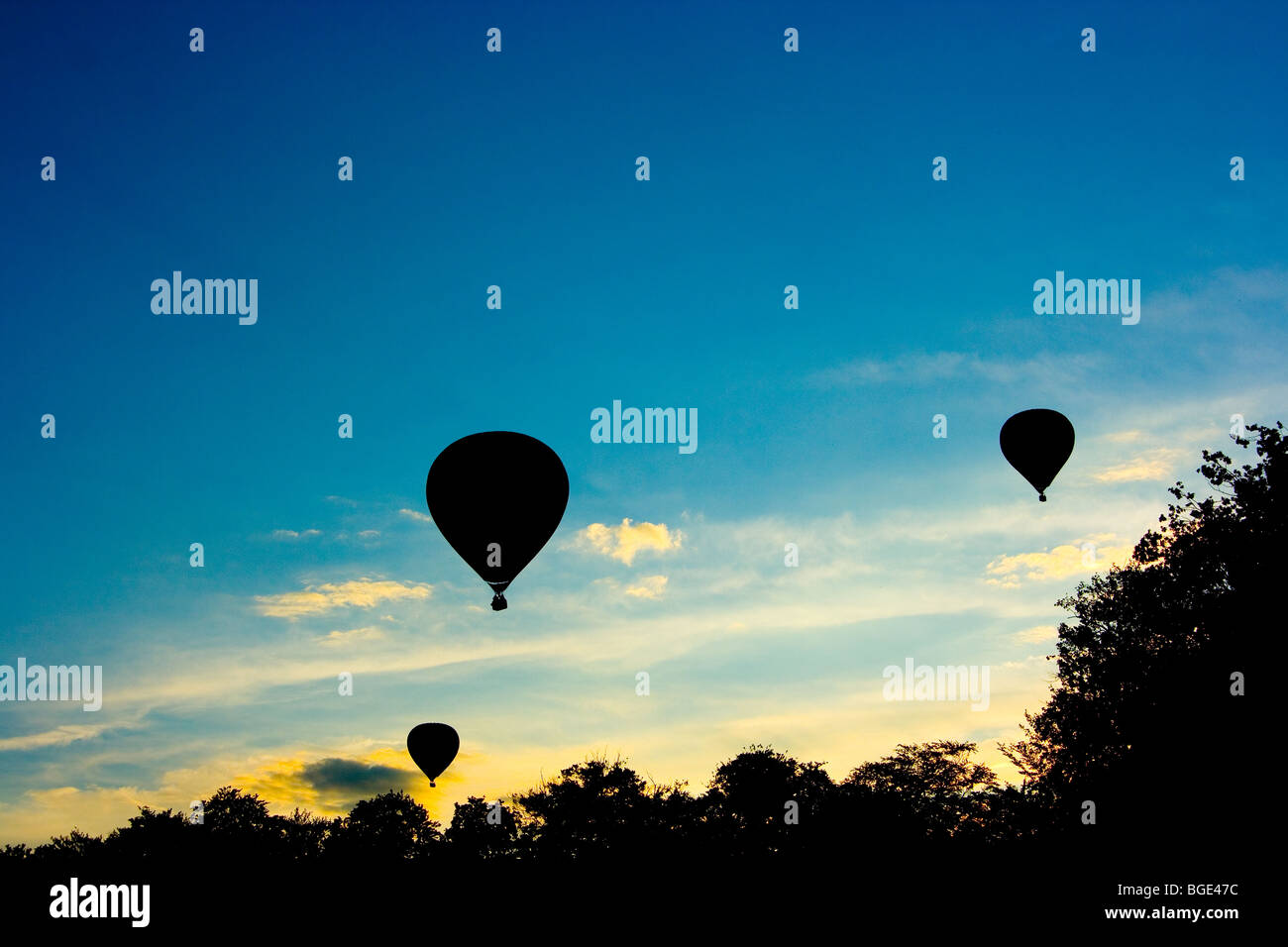 Trois ballons à air silhouetté contre le ciel du soir à Barneveld, aux Pays-Bas, à un festival de ballons Banque D'Images