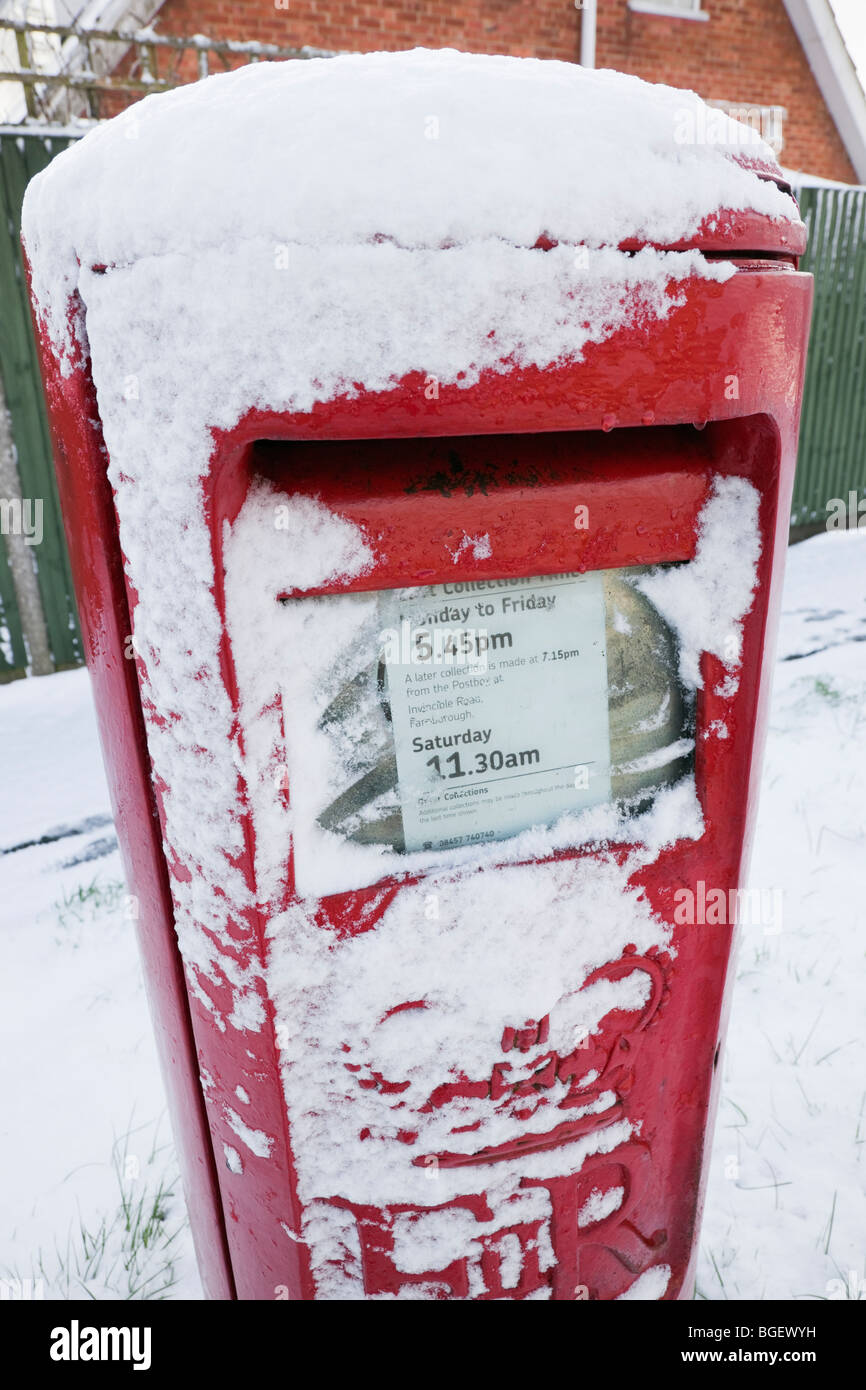 L'Angleterre, Grande-Bretagne, Royaume-Uni. Boite aux lettres rouge recouvert de neige en hiver Banque D'Images