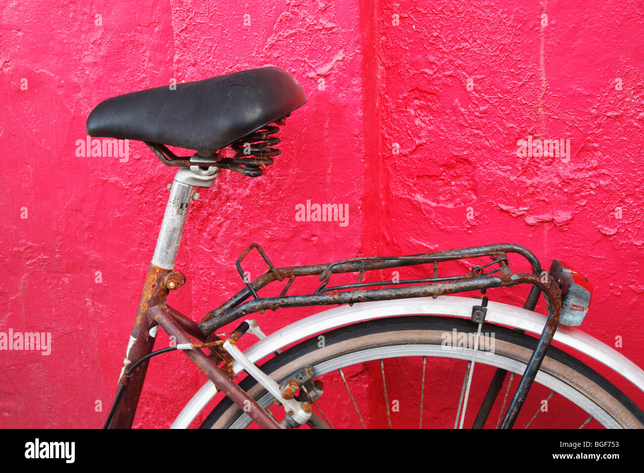 Vieux vélo contre le mur rouge Banque D'Images