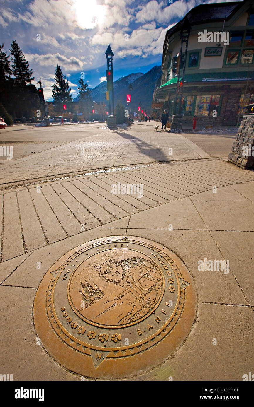 Plaque décorative dans le trottoir à l'angle de l'Avenue Banff et Wolf Street dans le centre-ville de Banff, Banff National Park, les Banque D'Images