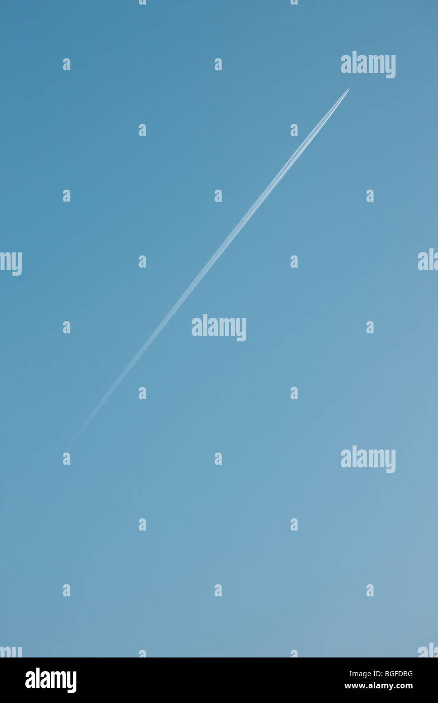 Vol à très haut et en laissant traînée de vapeur sur un ciel bleu clair Banque D'Images