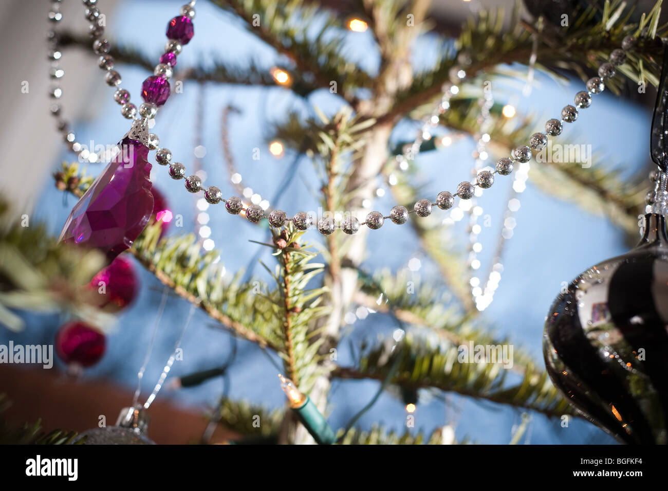 Décorations colorées joliment placé sur un pin (arbre de Noël dans un coin foom baie vitrée en décembre. Banque D'Images