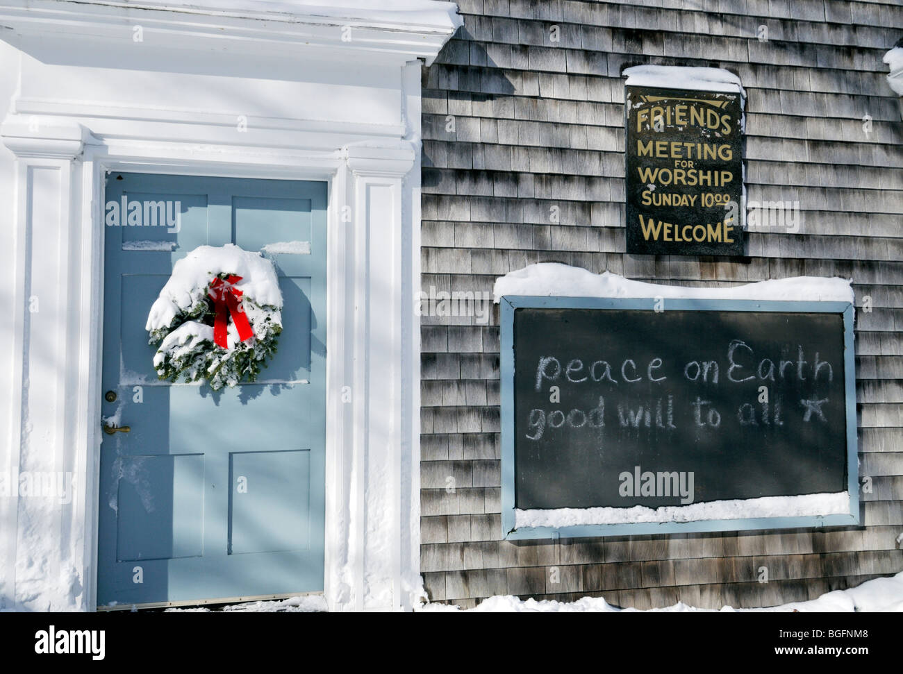 Evergreen christmas wreath with red bow couverte de neige fraîche sur la  porte d'un bois d'une maison de réunion,Cape Cod, USA Photo Stock - Alamy