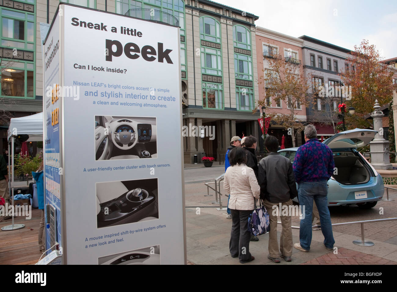 La lecture de l'affiche ' un sneak peek peu'. La Nissan LEAF Zero Emission Tour événement promotionnel. Banque D'Images La lecture de l'affiche ' un sneak peek peu'. La Nissan LEAF Zero Emission Tour événement promotionnel. Banque D'Images