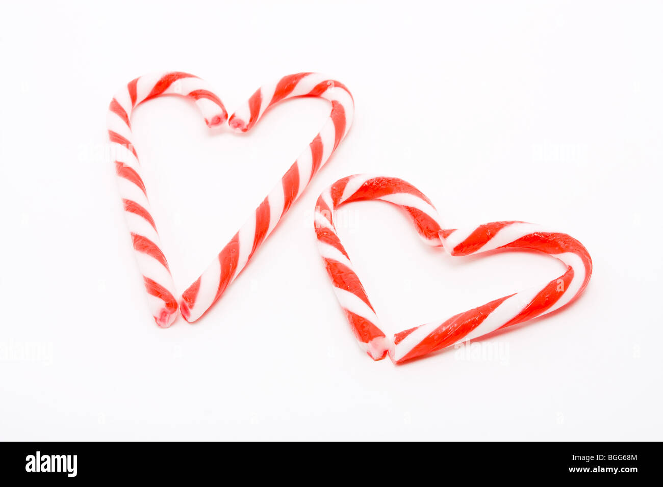 Des cannes de bonbon disposés en forme de coeur contre fond blanc pour exprimer le concept de la Saint-Valentin. Banque D'Images