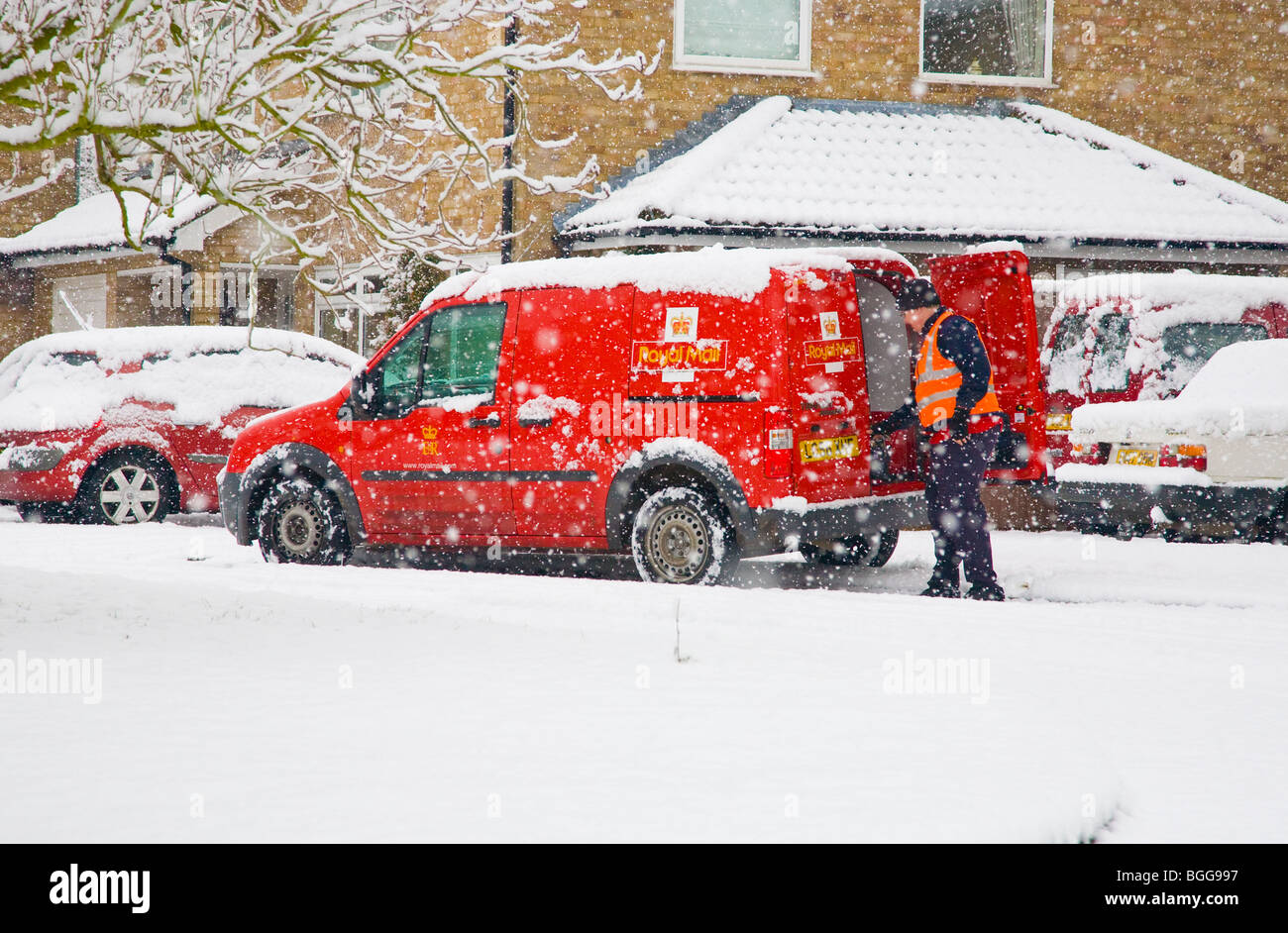 Postman livrer du courrier lors d'une forte tempête de neige Banque D'Images