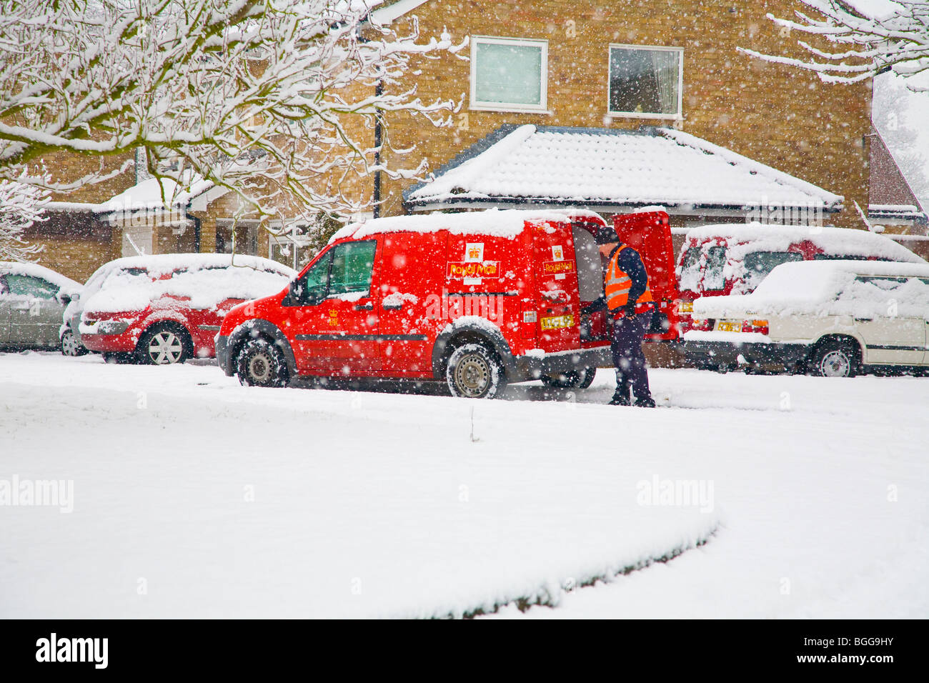 Postman livrer du courrier lors d'une forte tempête de neige Banque D'Images