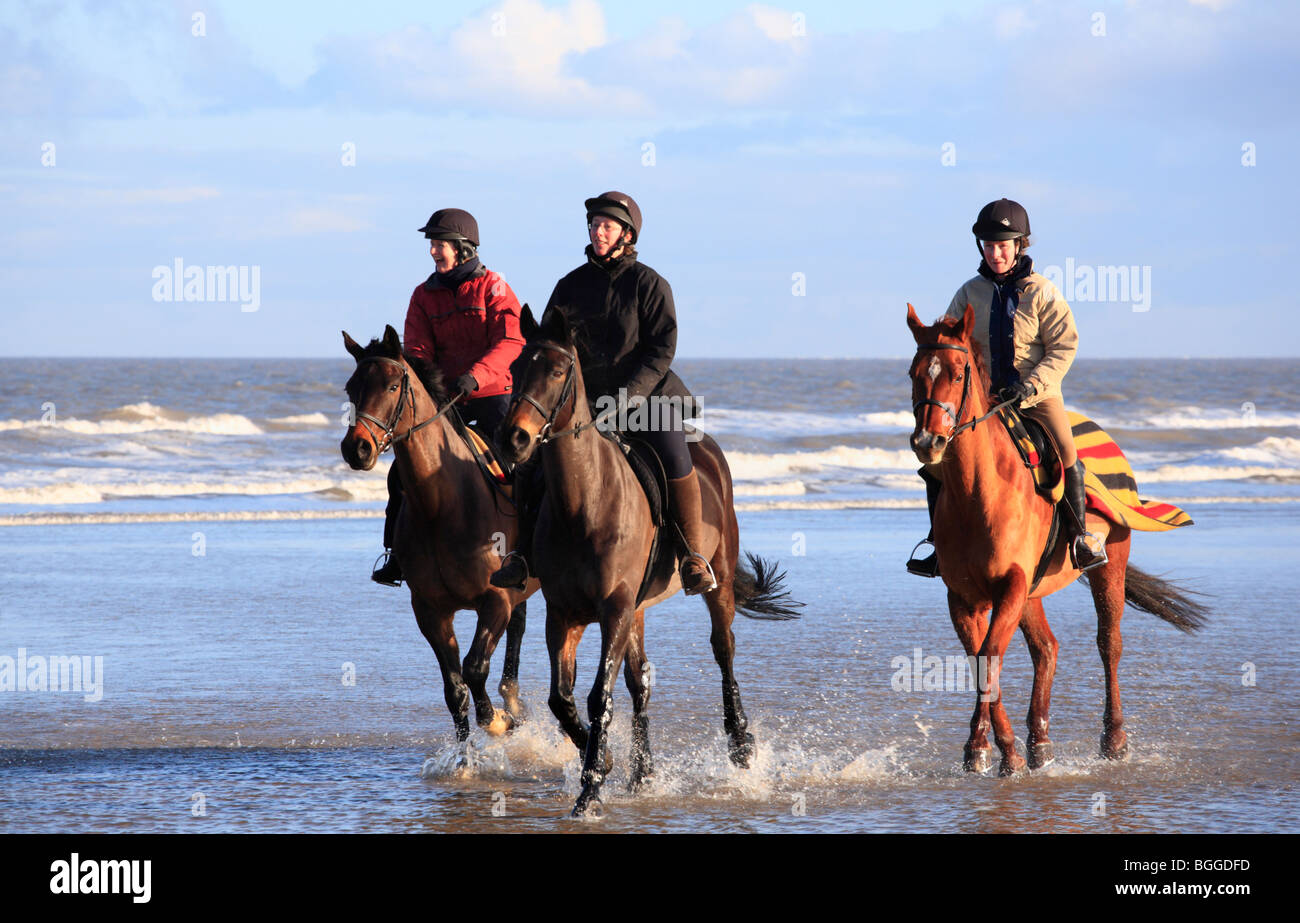 Trois cavaliers sur la plage Équitation à Burnham Overy de Holkham le jour de l'an 2010. Banque D'Images